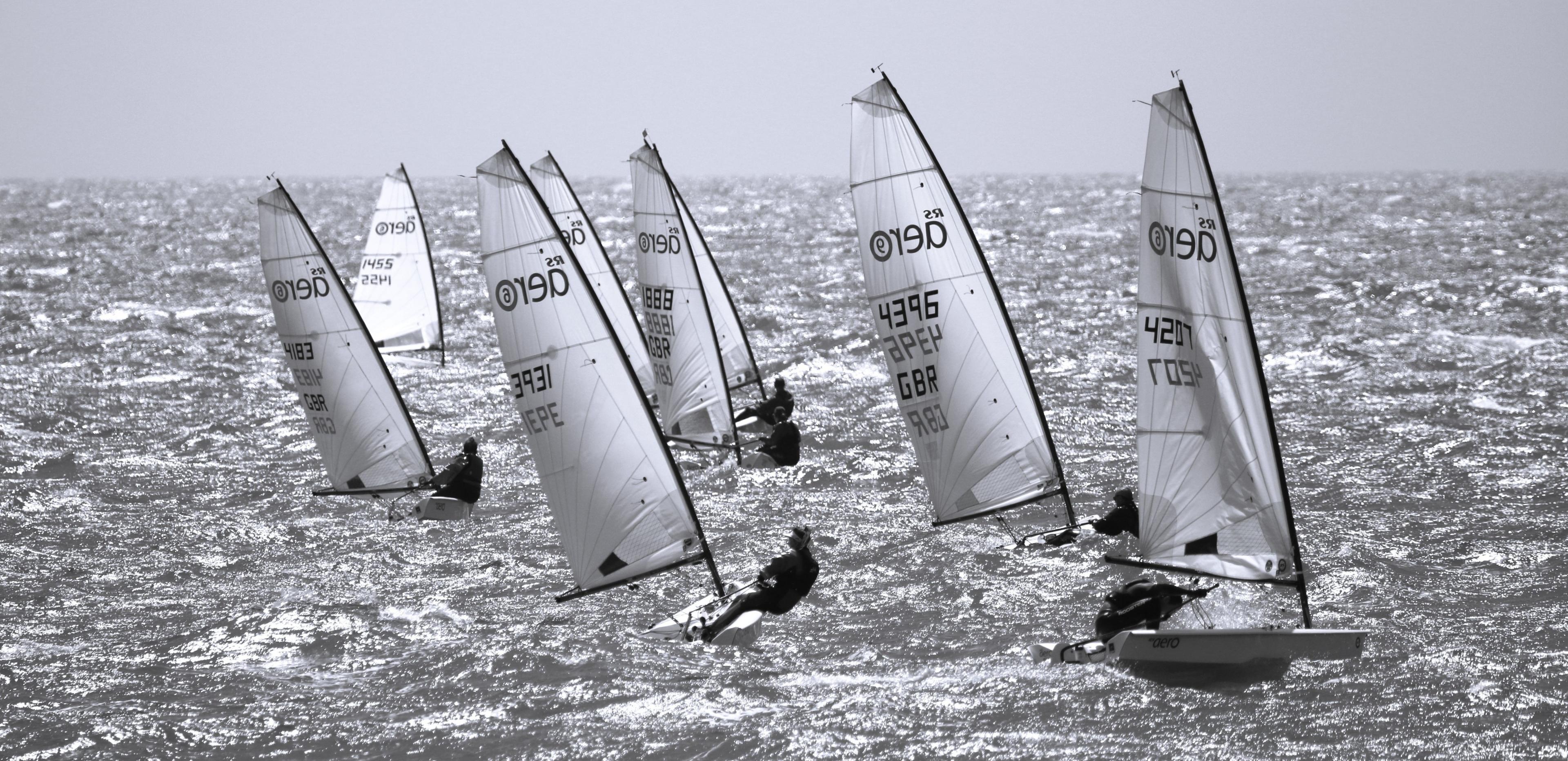 Aero dinghies head towards the camera on choppy seas