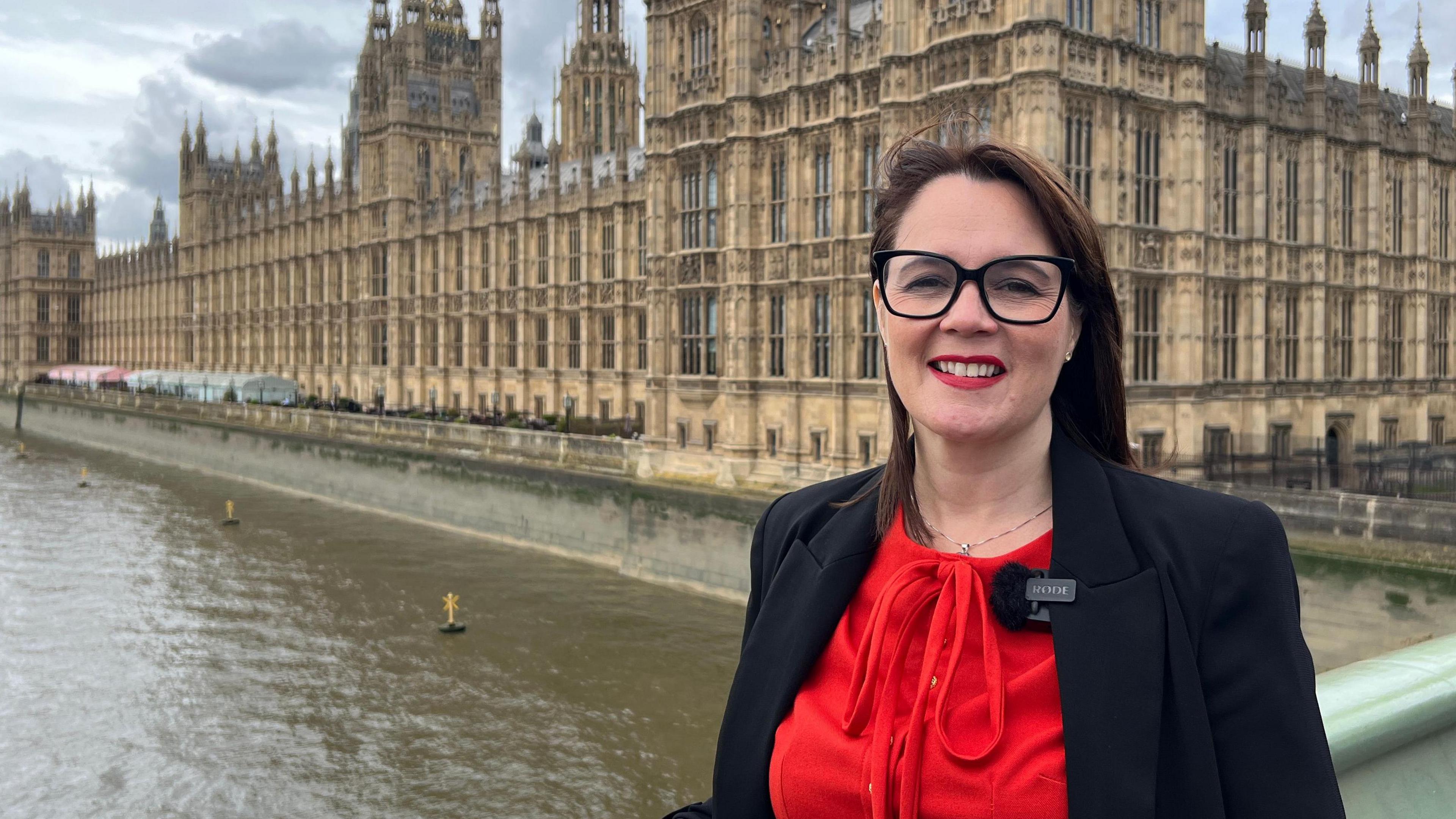 Linsey Farnsworth stood in front of the Houses of Parliament in London