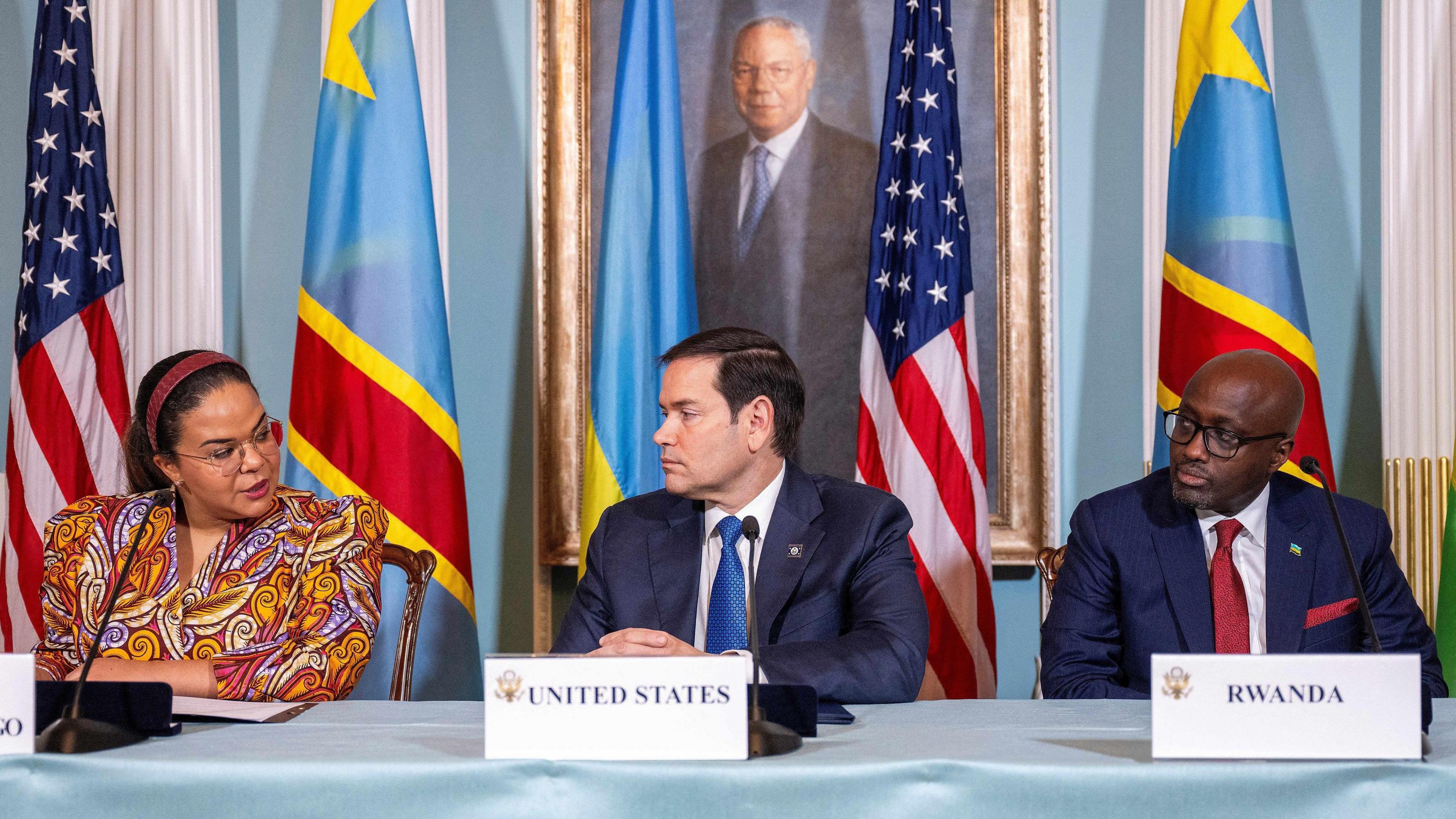 Democratic Republic of the Congo's foreign minister Therese Kayikwamba Wagner, US Secretary of State Marco Rubio and Rwanda's foreign minister Olivier Nduhungirehe sit at a table in front of a backdrop which includes the flags of the USA, DR Congo and Rwanda