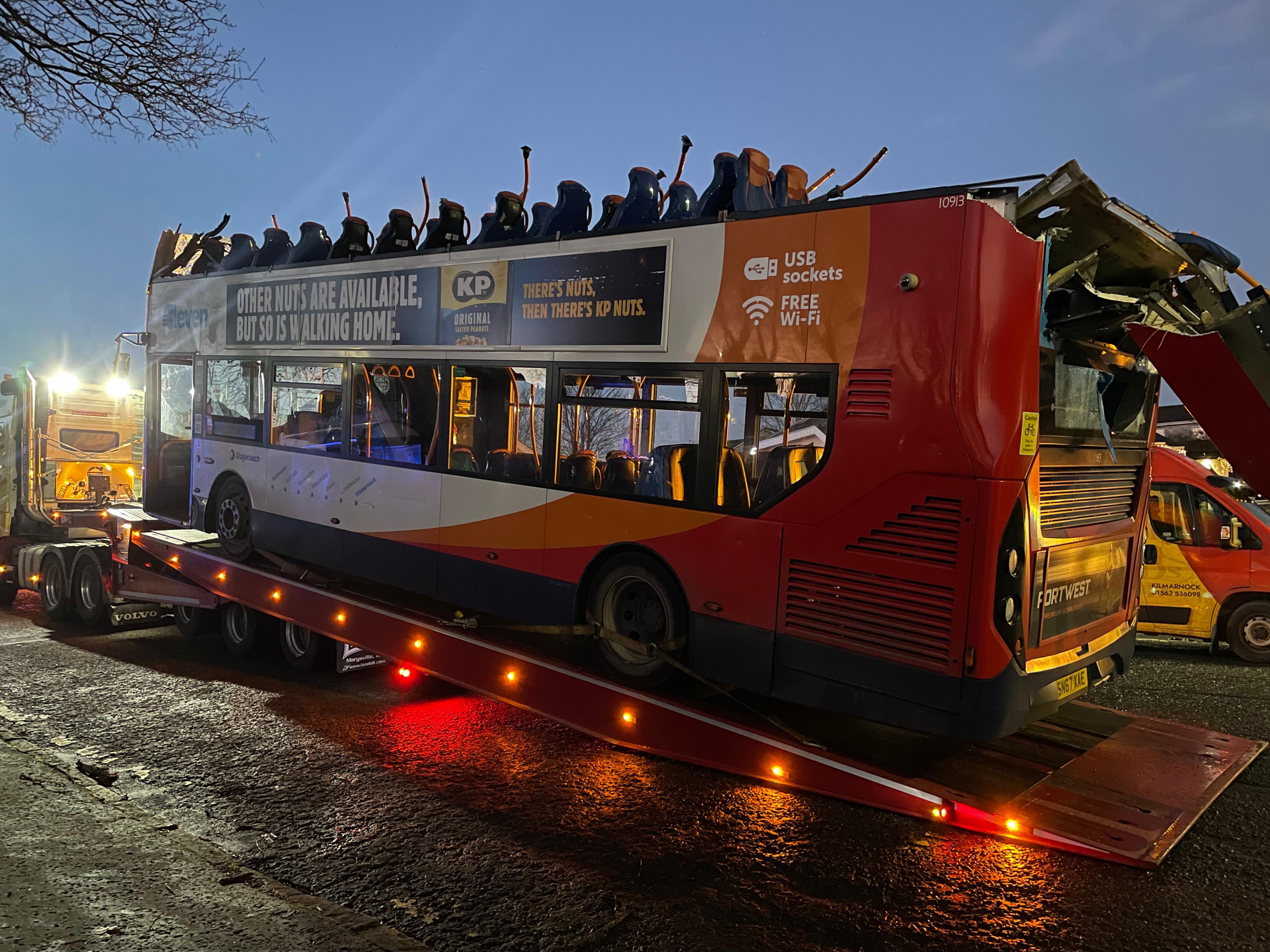 A roofless double decker Stageboach bus being loaded onto the back of a lorry