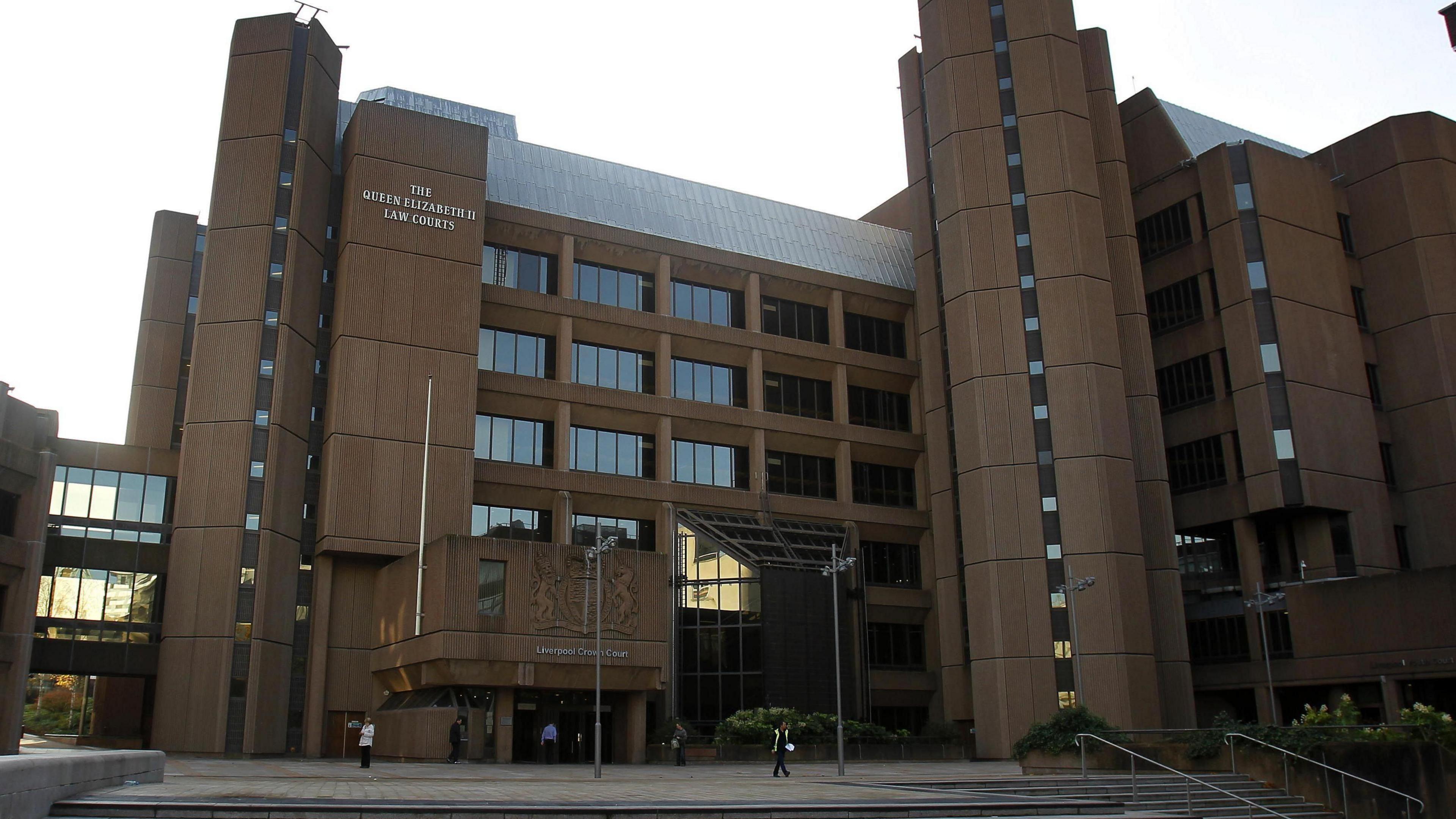 Liverpool Crown Court, which is a brown concrete multi-storey structure with a glass reception area.