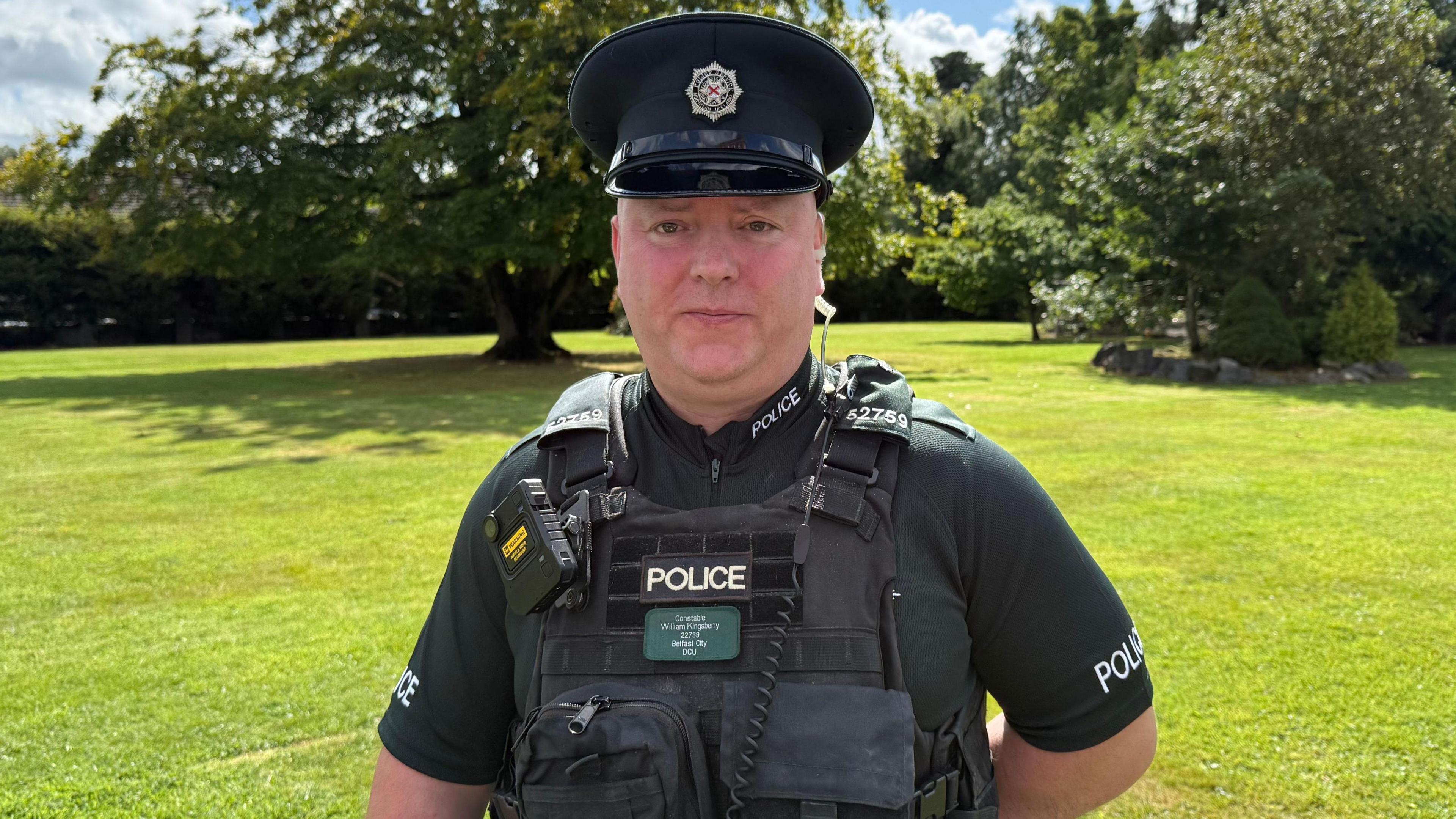 William Kingsberry wearing a dark green PSNI uniform, he is looking at the camera.
