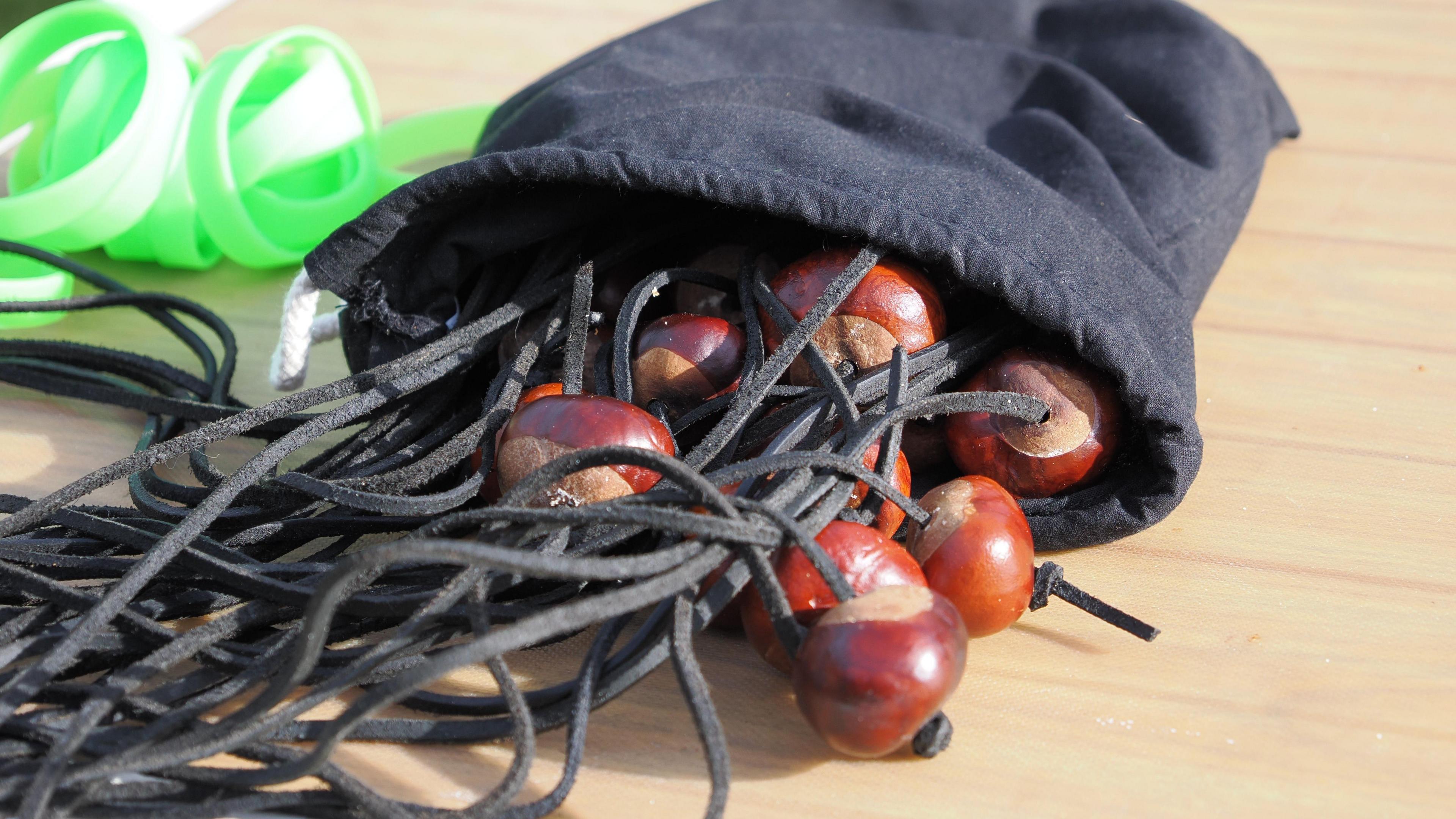 A small black bag full of conkers tied to strings