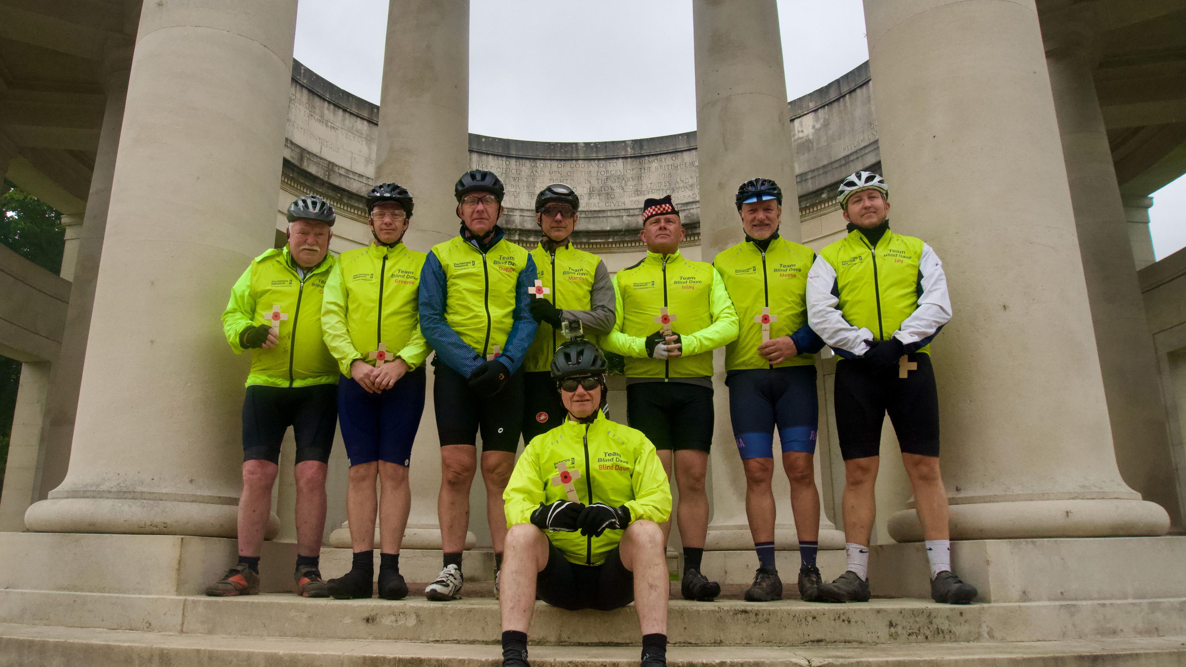 Eight cyclists at a war memorial