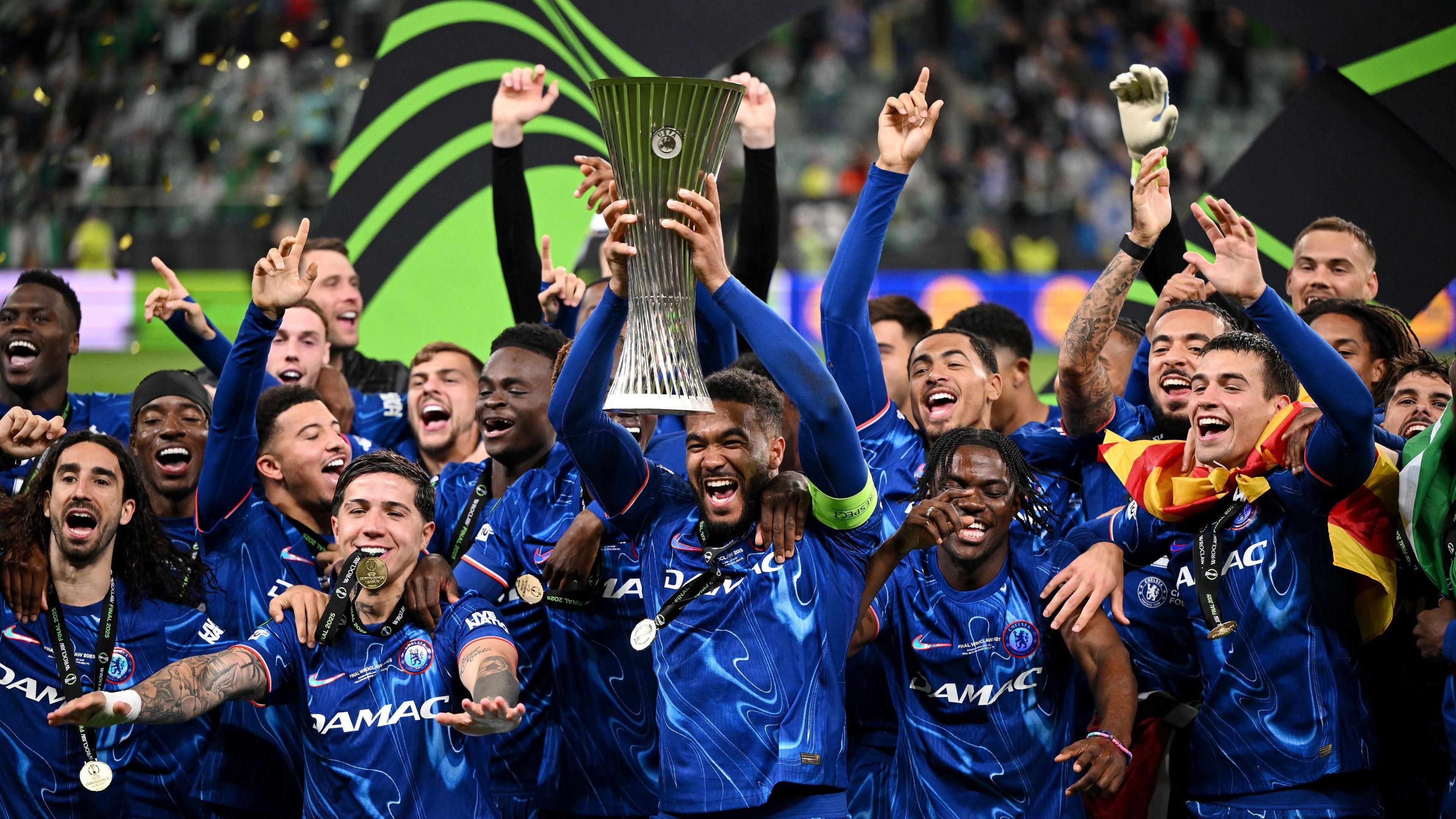 Chelsea captain Reece James lifting the Conference League trophy surrounded by his happy teammates.
