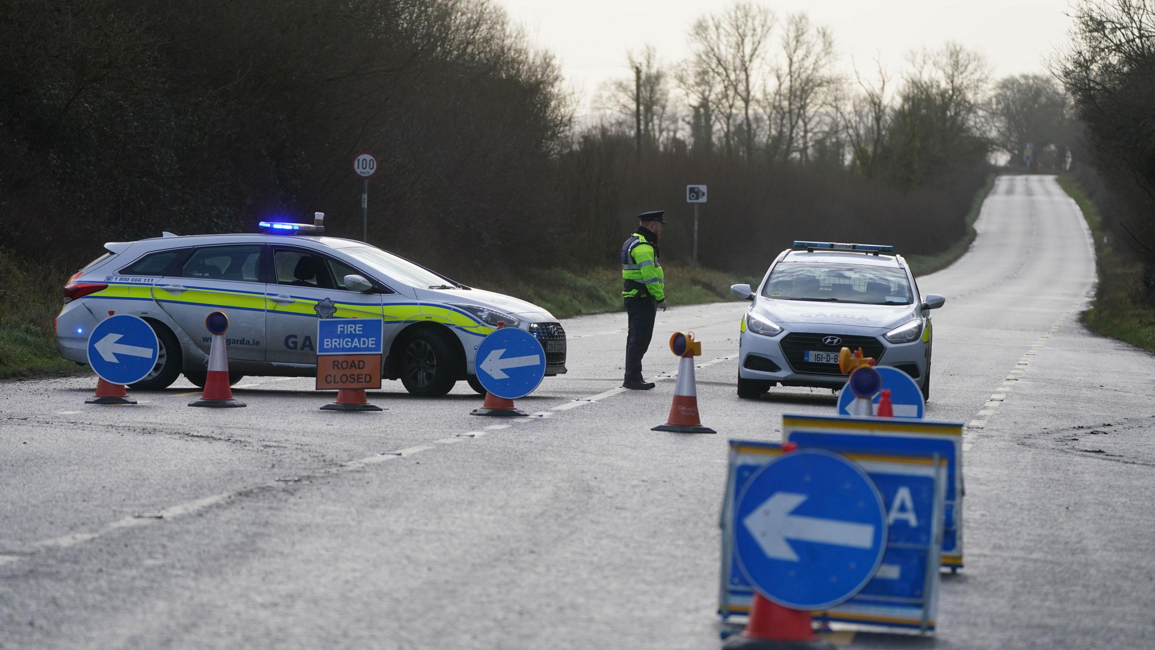 A Garda officer stands at a roadblock on the N80 at Leagh on the Wexford Road, in Co Carlow, where three people have been killed in a single-vehicle accident on Wednesday evening.