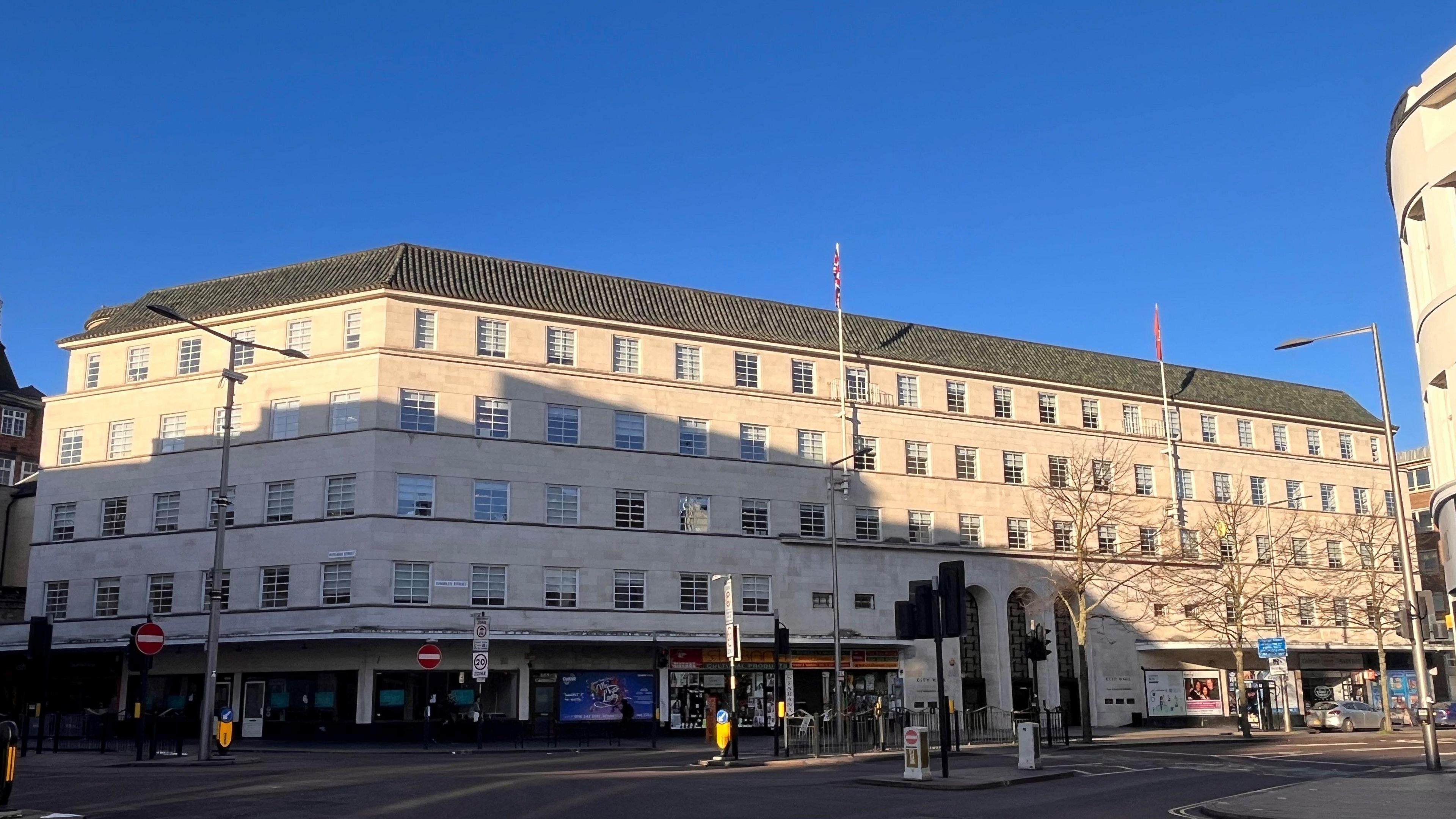 The exterior of Leicester City Council's headquarters - a white stone building with three tall archways over the entrances