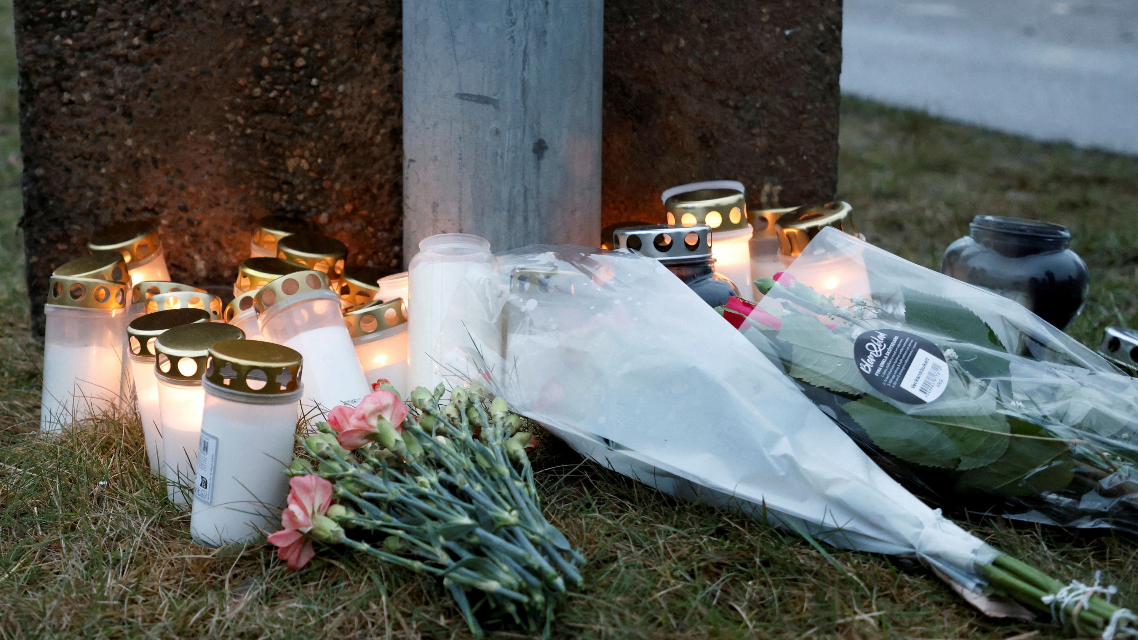 Flowers and candles are placed near the Risbergska School on Wednesday, the day after a mass shooting there killed around 10 people