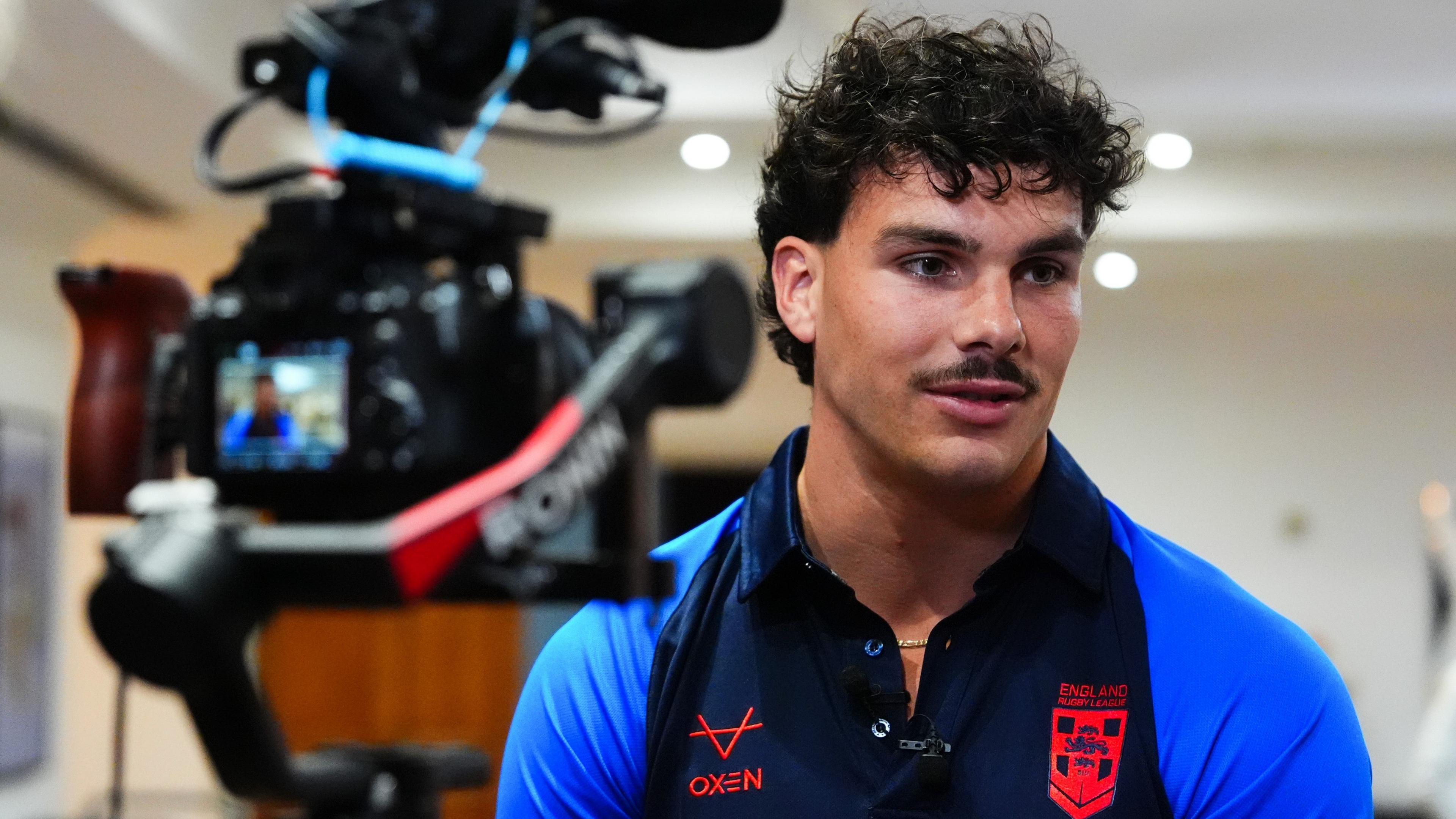 Herbie Farnworth looks off to the right while being filmed with a camera