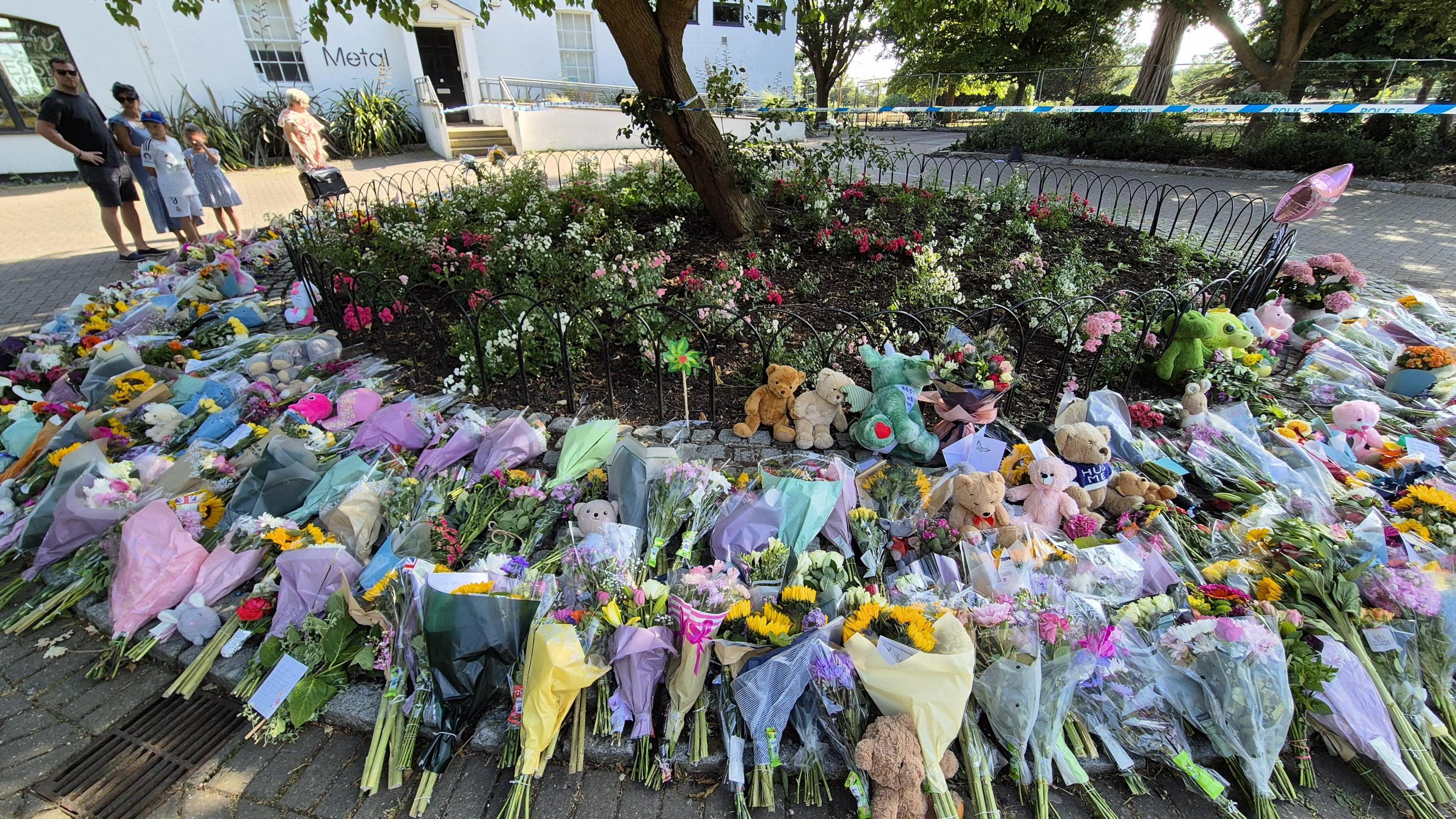Hundreds of flowers left by a tree in a park 