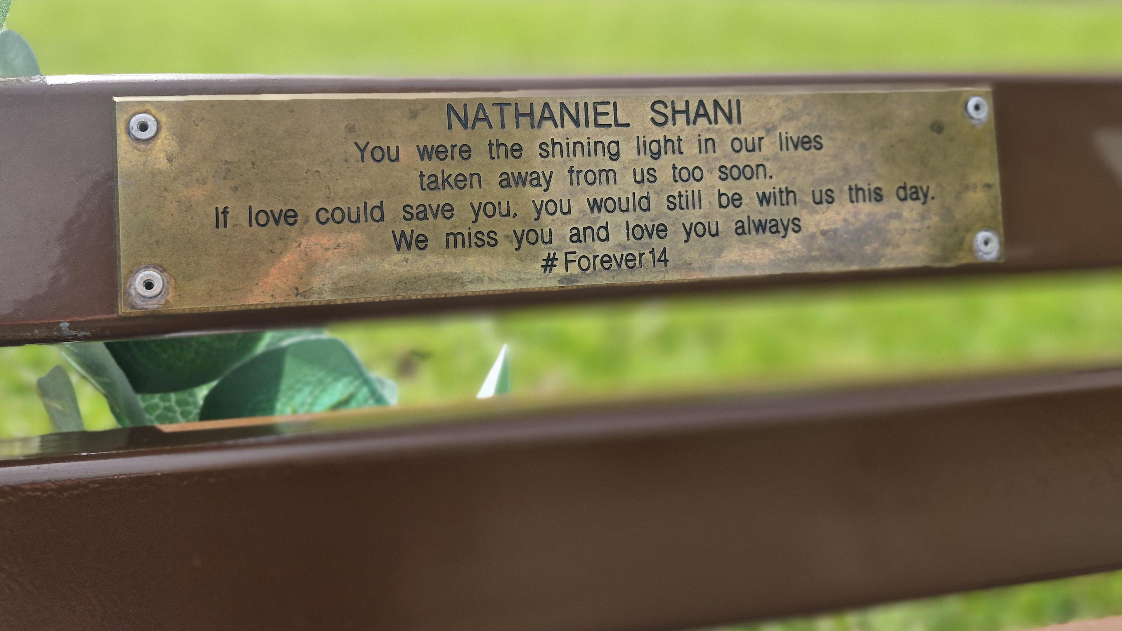 Close up of the plaque on Nathaniel's bench. It reads: "Nathaniel Shani. You were the shining light in our lives taken away from us too soon. If love could save you, you would be with us this day. We miss you and love you always." 