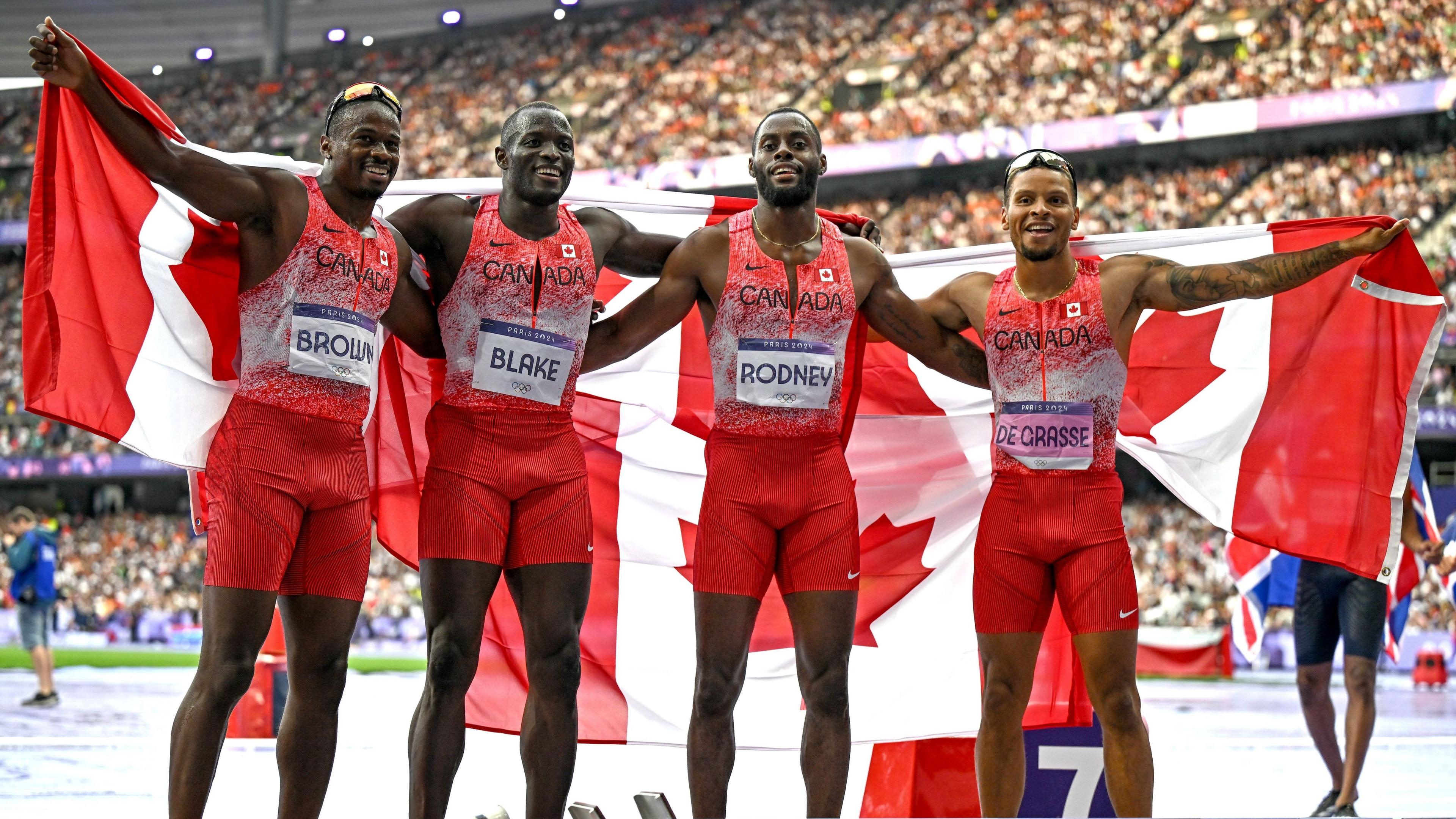 Seven-time Olympic medallist Andre de Grasse with Canada team-mates Aaron Brown (left), Jerome Blake (left centre) and Brendon Rodney (right centre), posing with flags