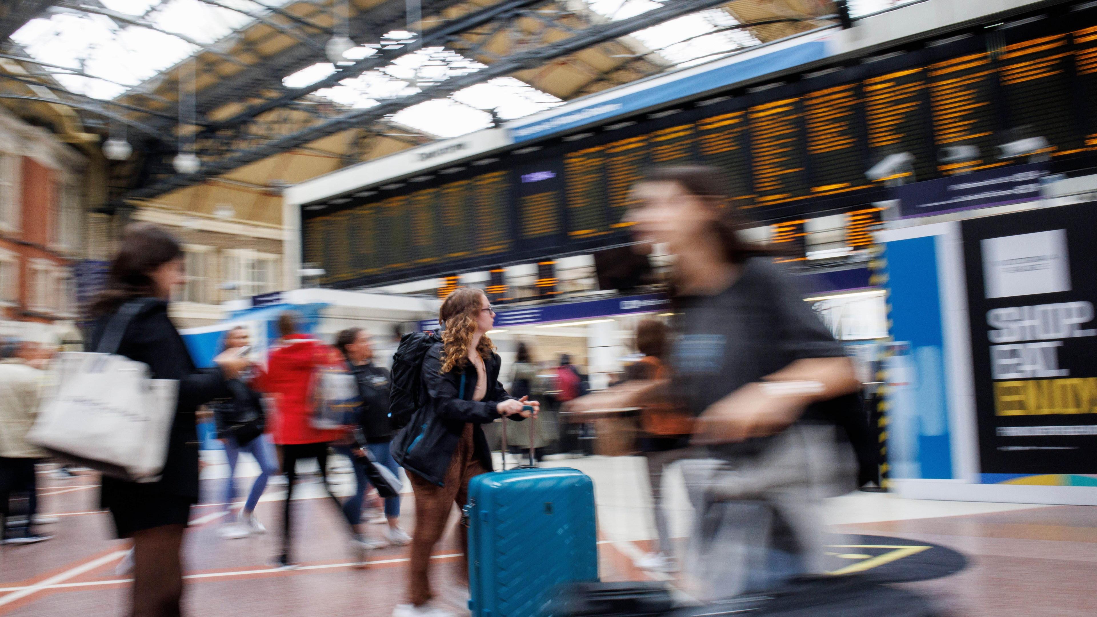 Passengers wait for train services at Victoria Station. Blurred stock photo