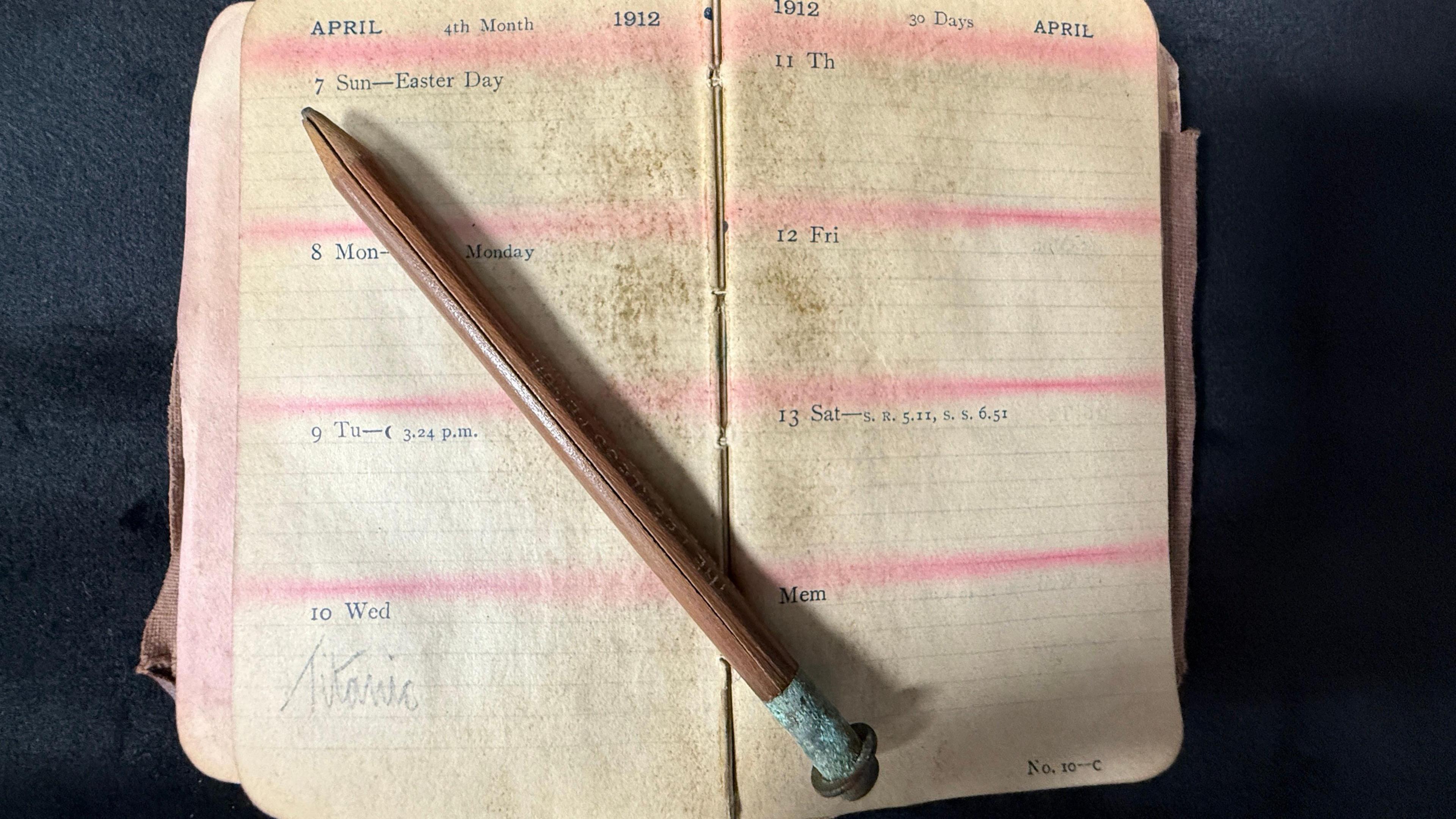 A view of the open page in the diary that shows the word "Titanic". A pencil is rested across the pages.