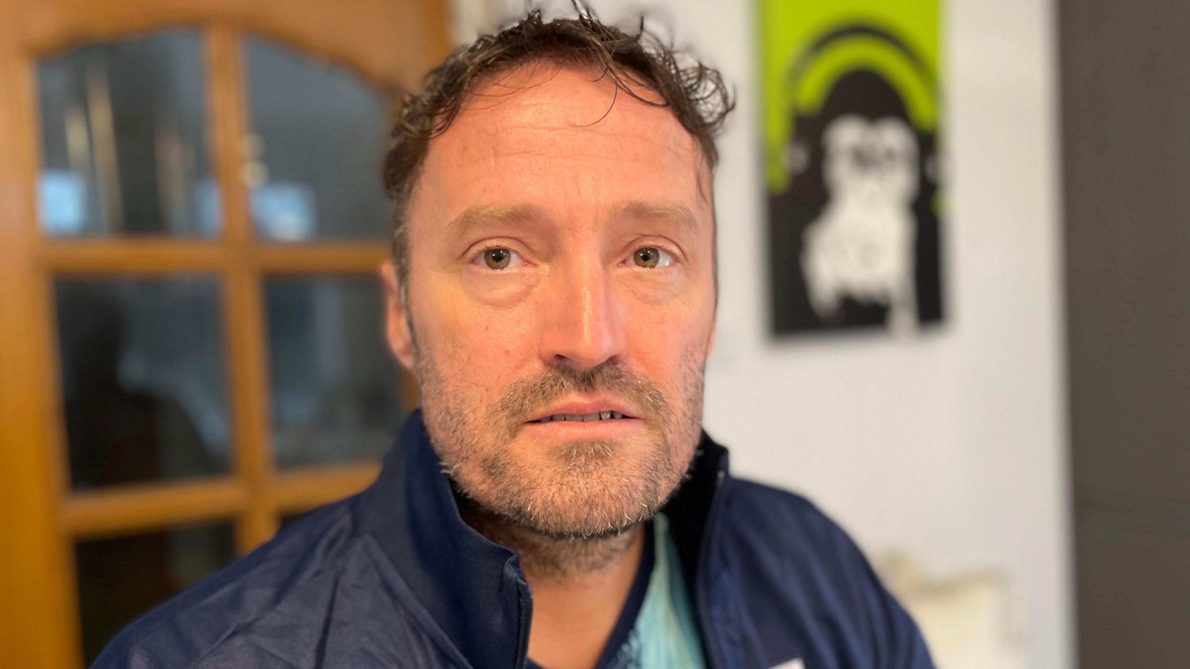 Man in his forties with a blue jacket and short hair