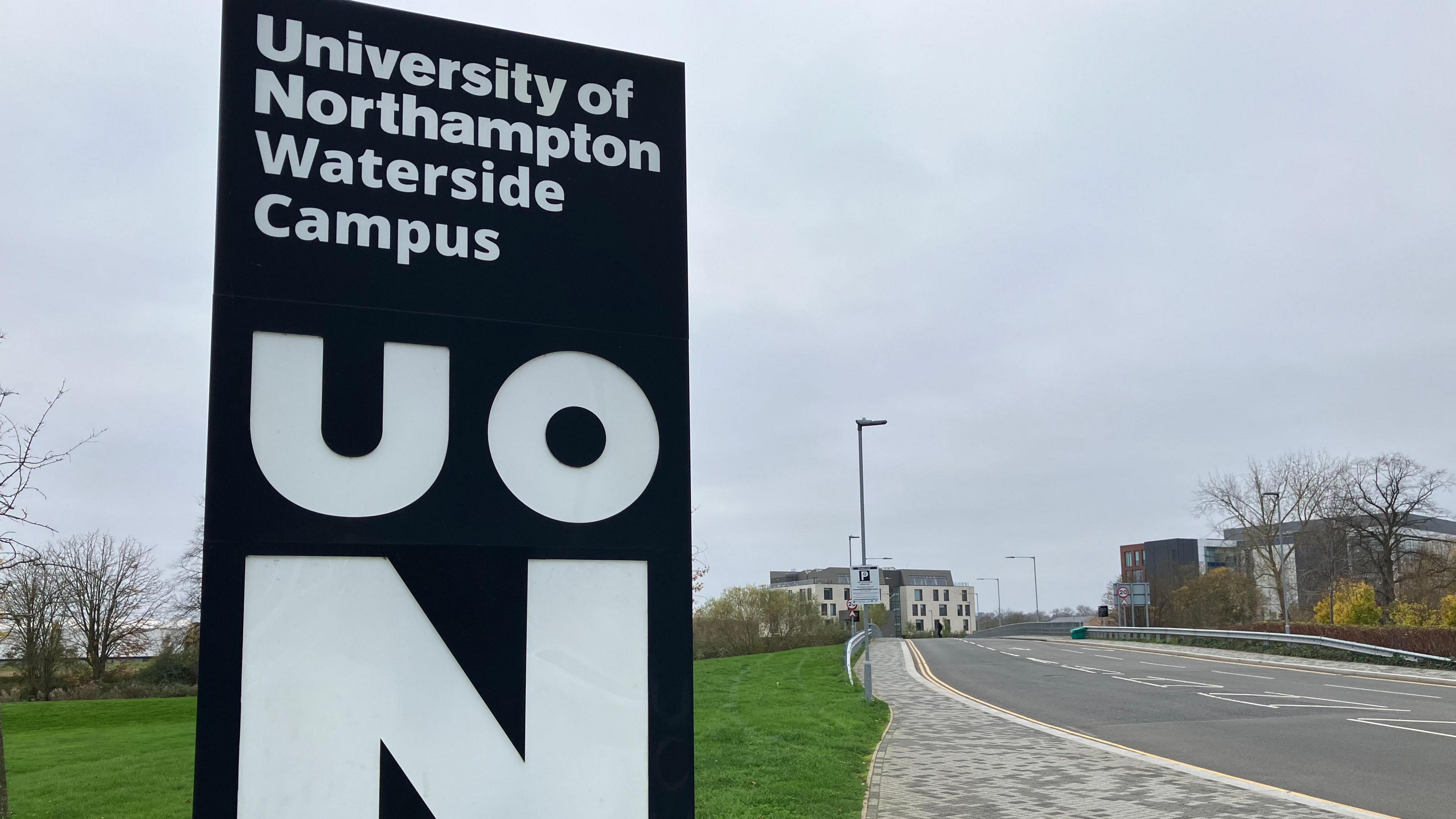 A black column sign marking the location of the University of Northampton and its Waterside Campus.