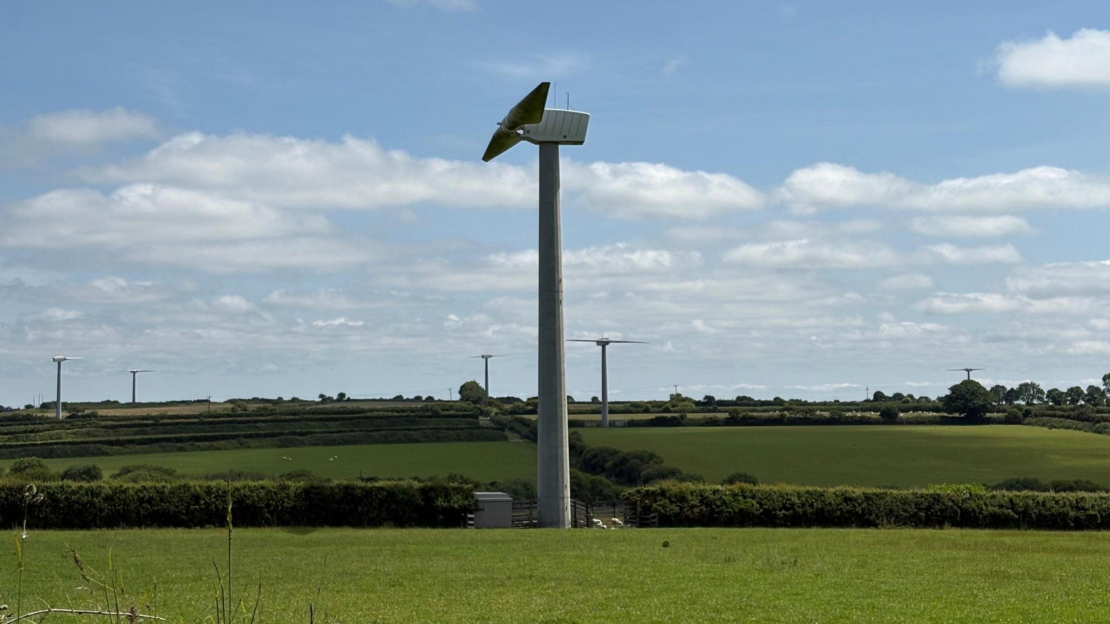A series of wind turbines on green hills