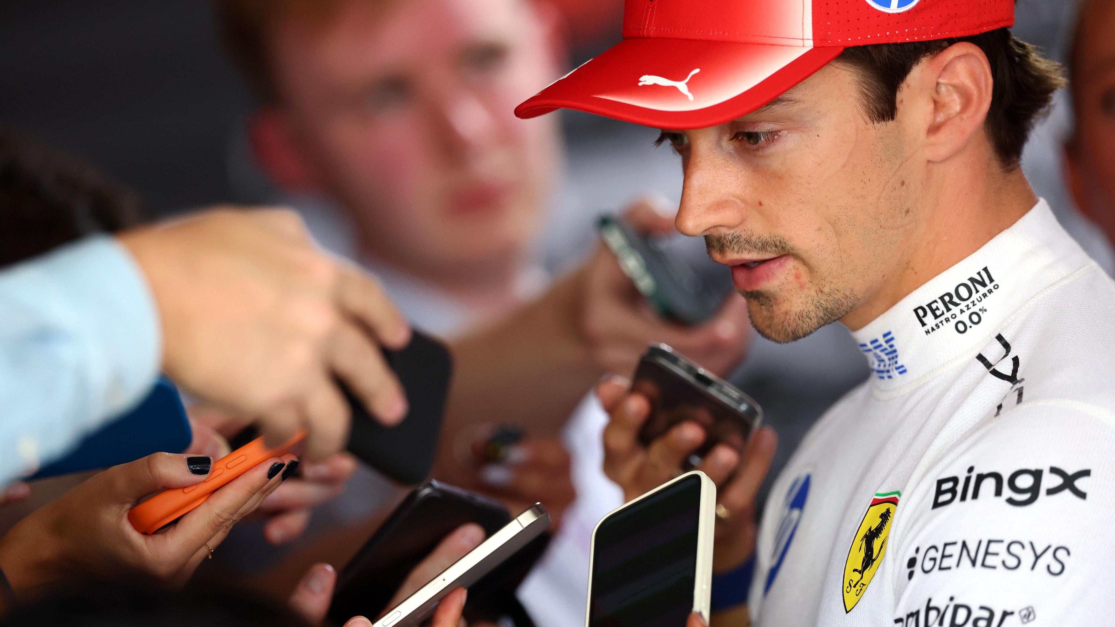 Journalists hold their phones up to record their interviews with Ferrari's Charles Leclerc following qualifying for the Barcelona-Catalunya Grand Prix