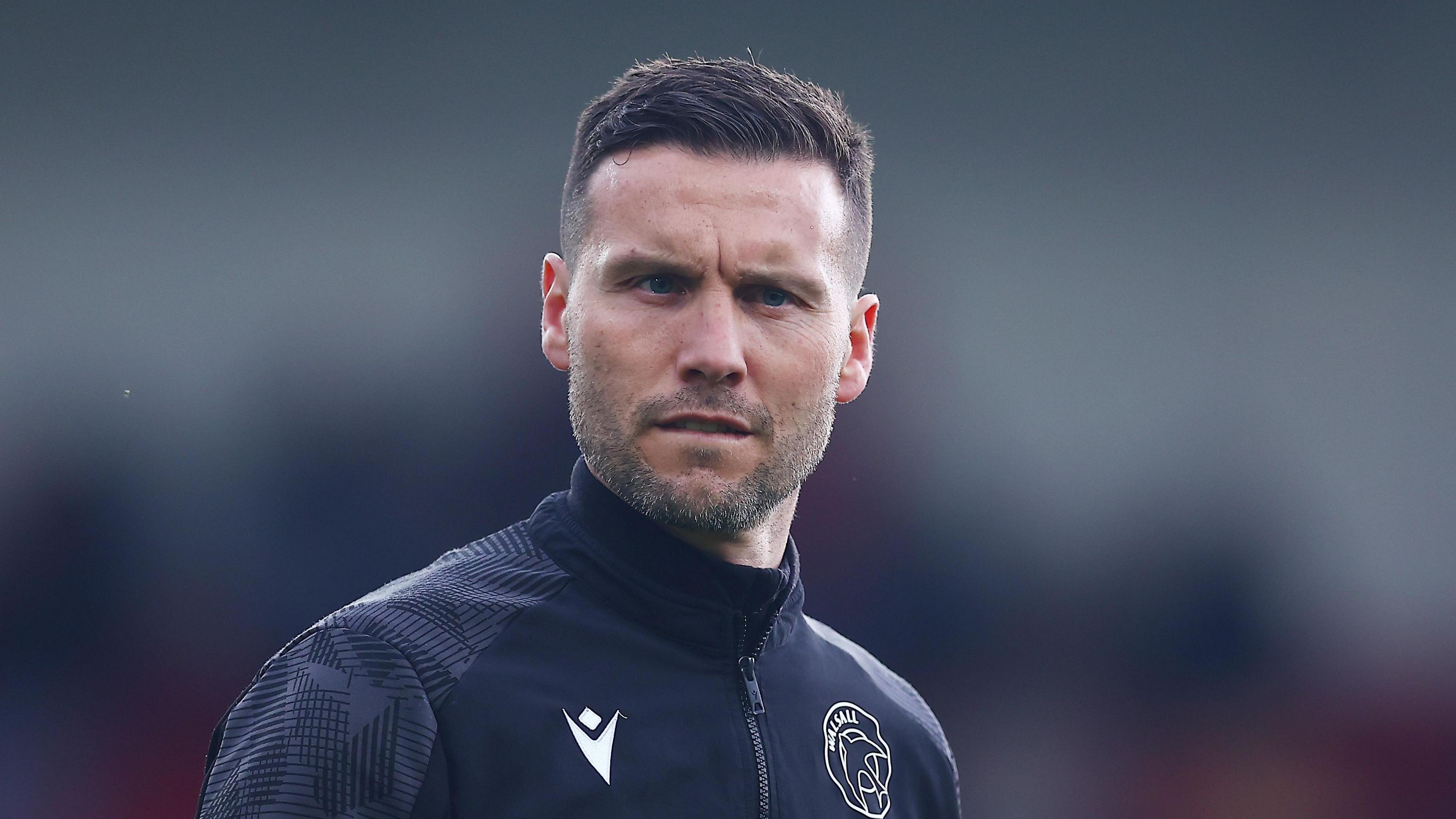 Walsall boss Mat Sadler looks on,