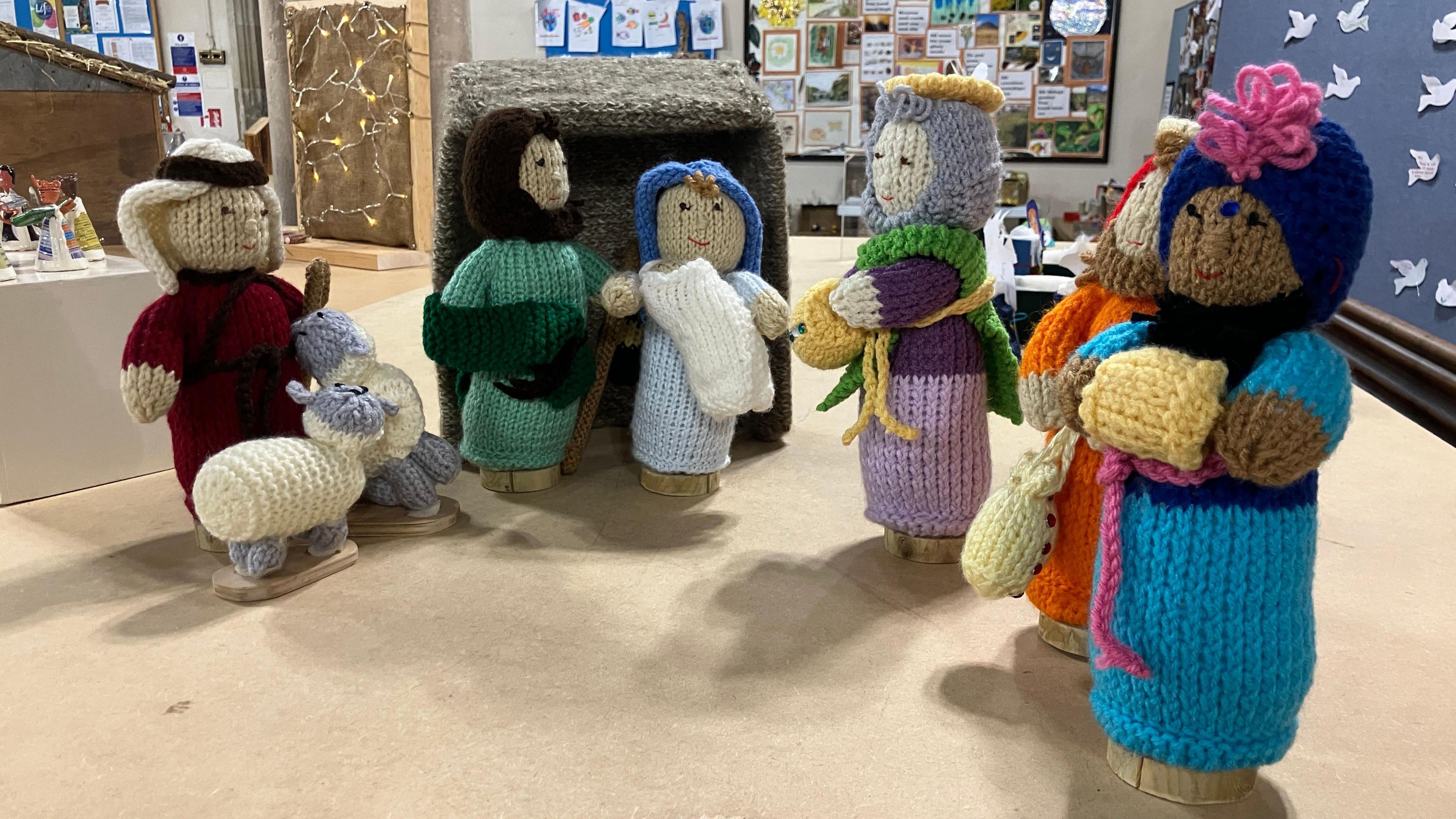 A crocheted nativity scene. Figures of a shepherd, Mary, Joseph and baby Jesus can be seen. 