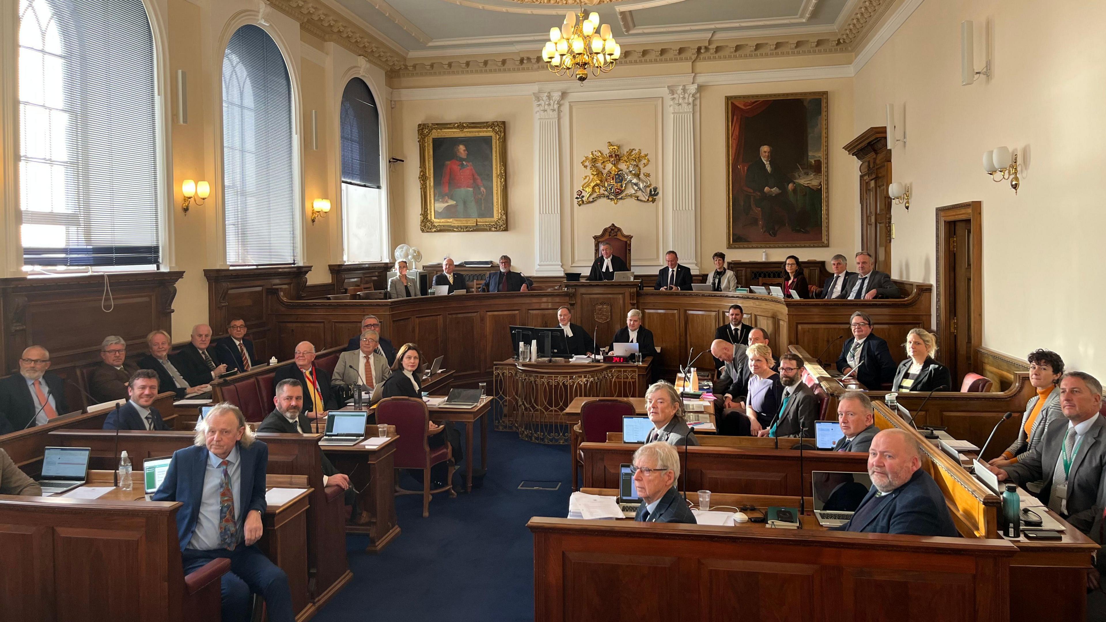 A group of people wearing suits looking towards the camera in a courtroom setting. 