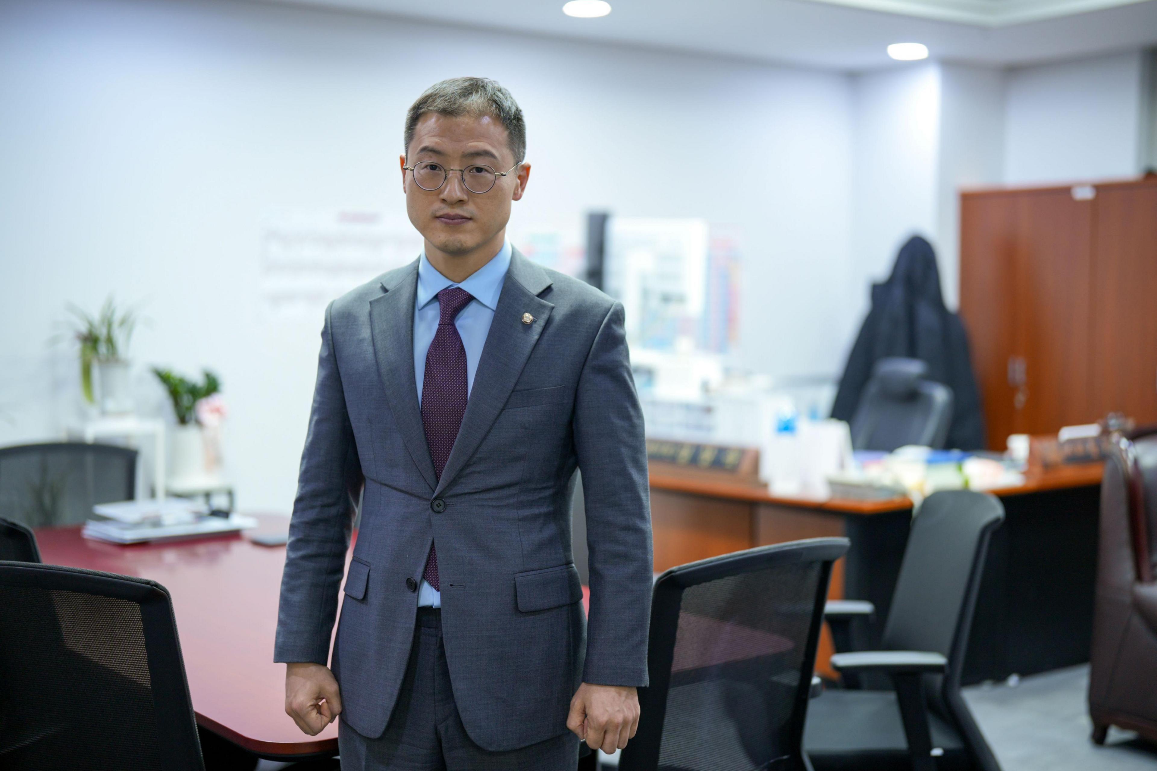 Kim Sang-wook stands in an office