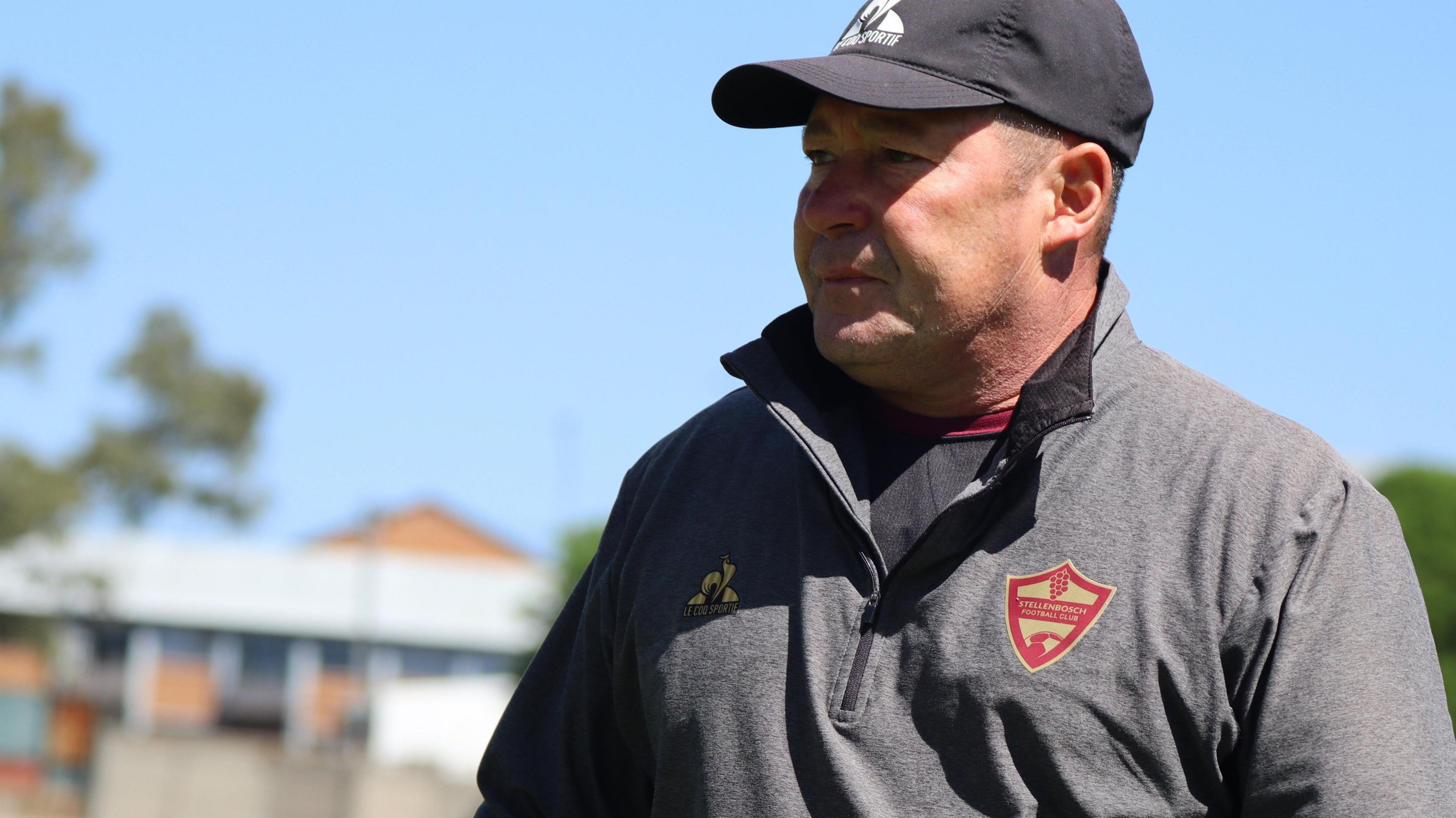 Steve Barker wears a cap and Stellenbosch-branded top during a training session