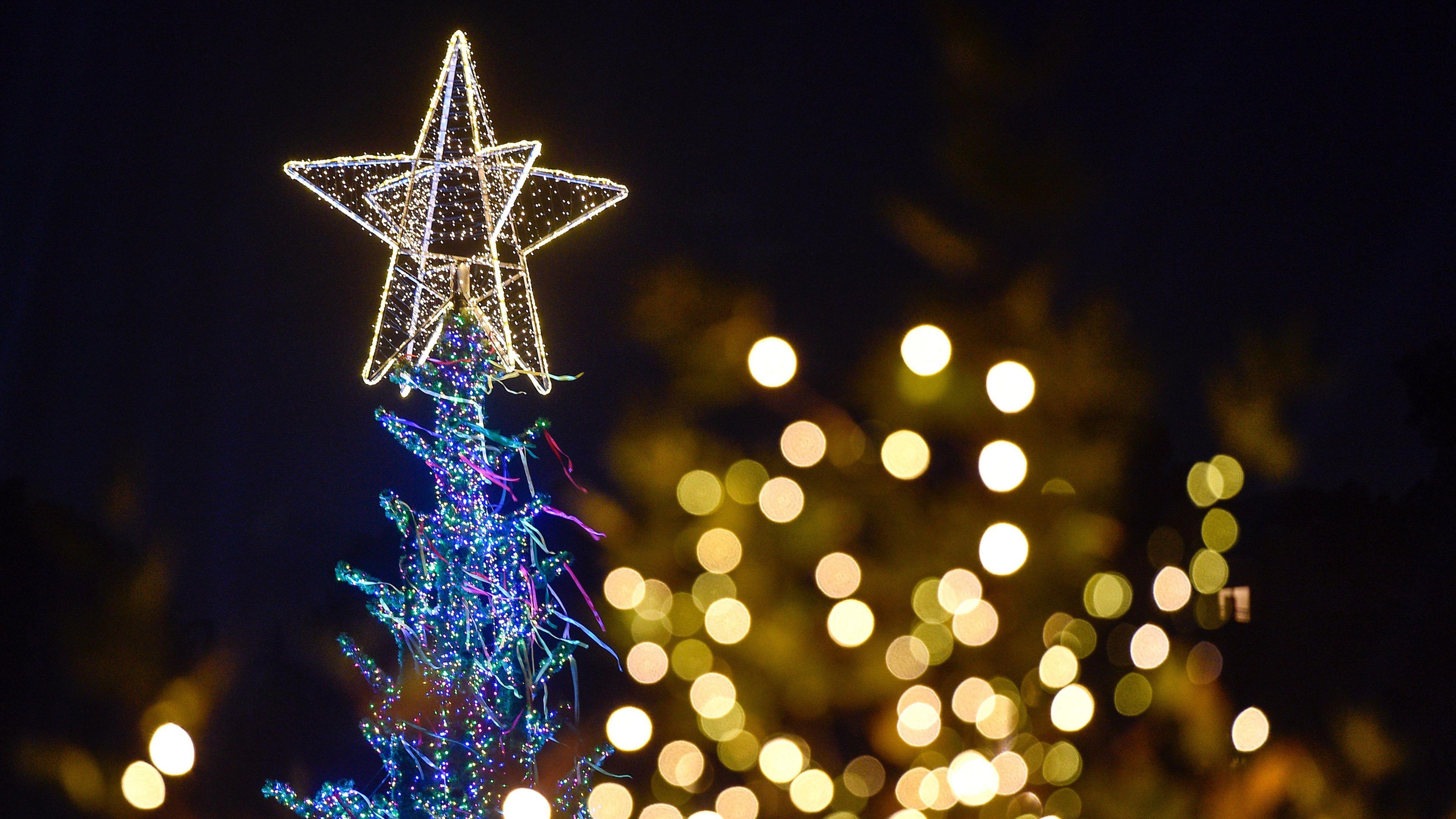 A lit up Christmas tree tip with a glowing star on the top