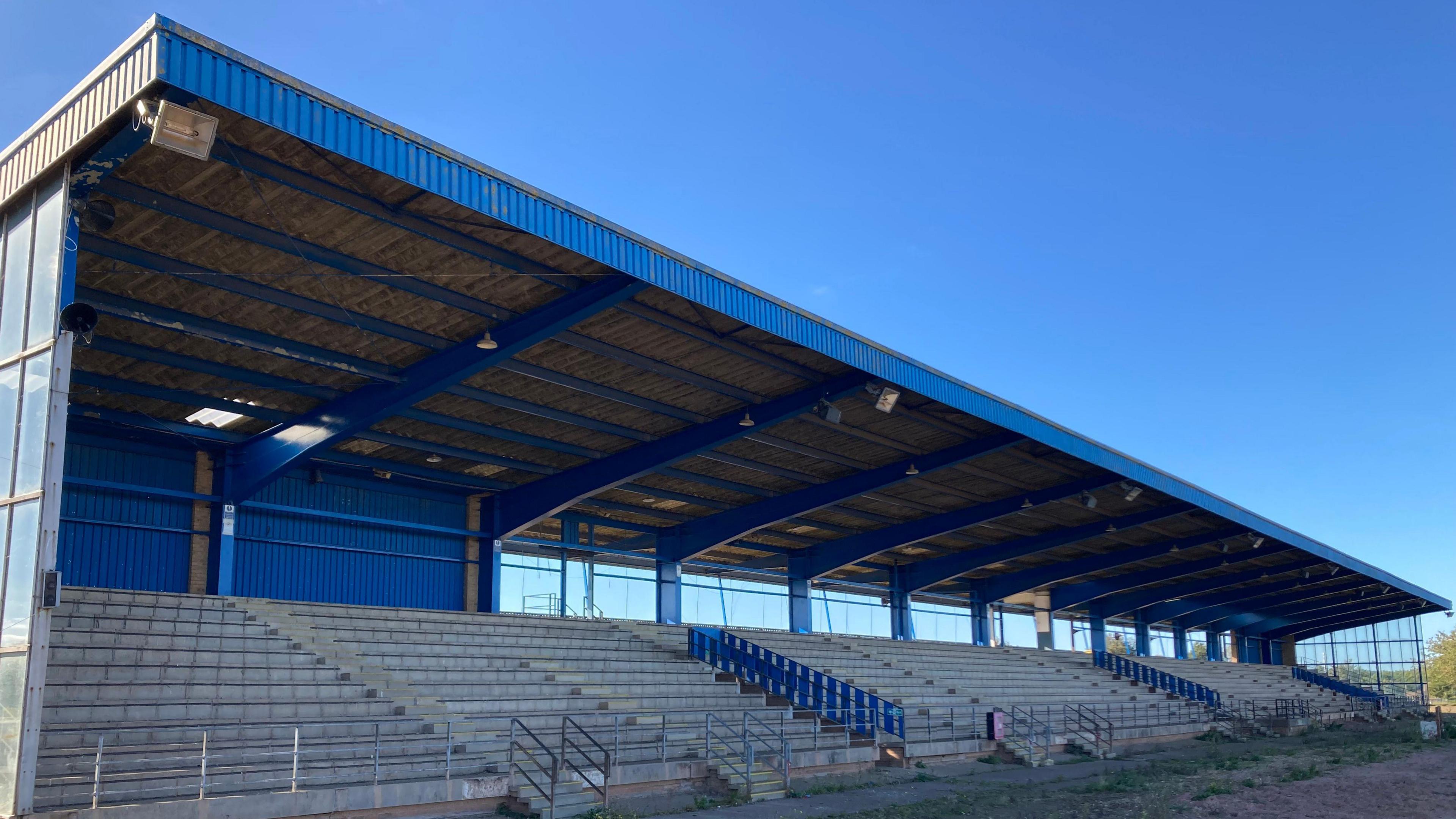 The speedway grandstand, which shows chairs have been removed from it