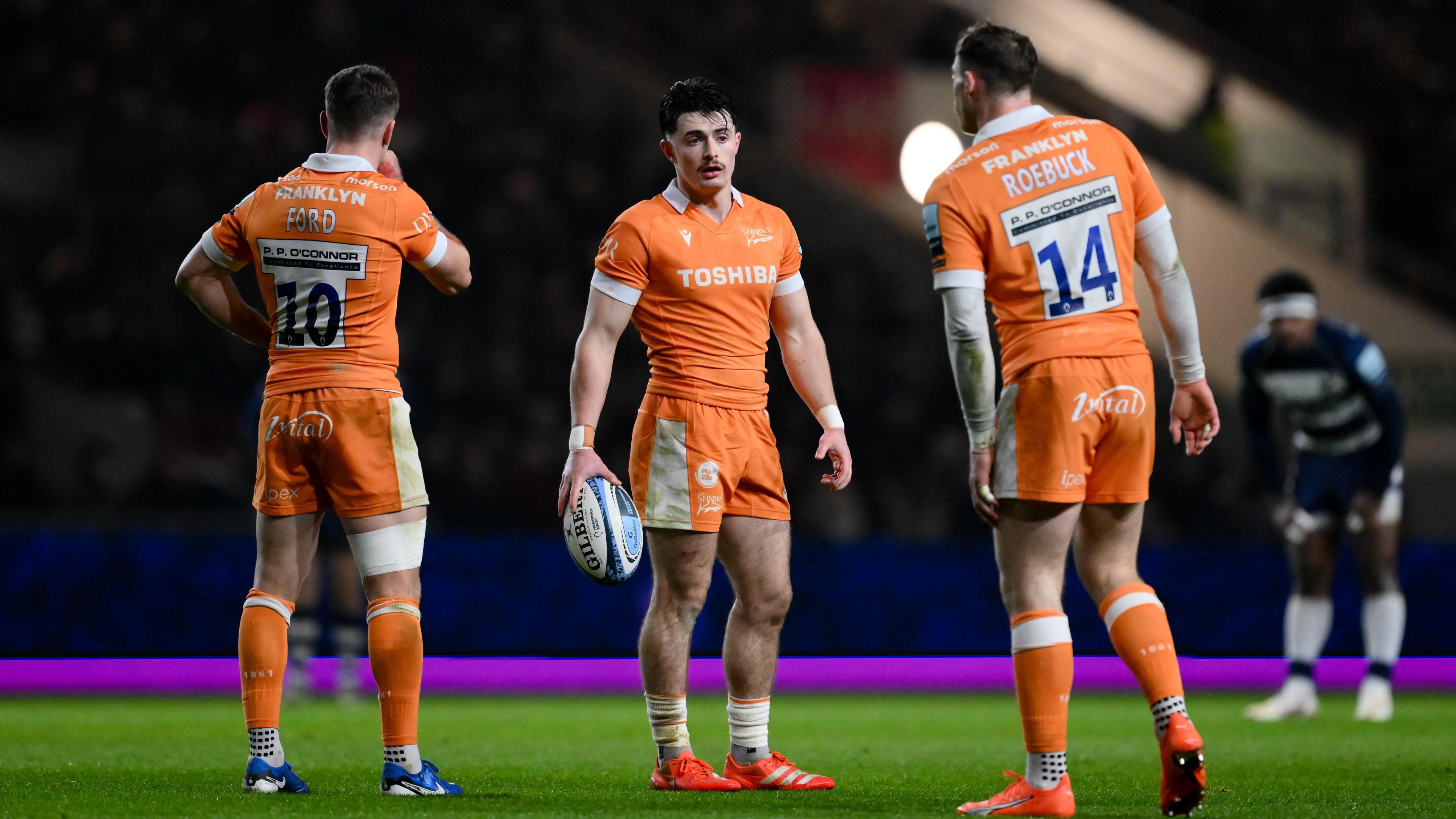 George Ford, Raffi Quirke and Tom Roebuck in discussion while wearing Sale's away kit during the 38-0 win over Bristol