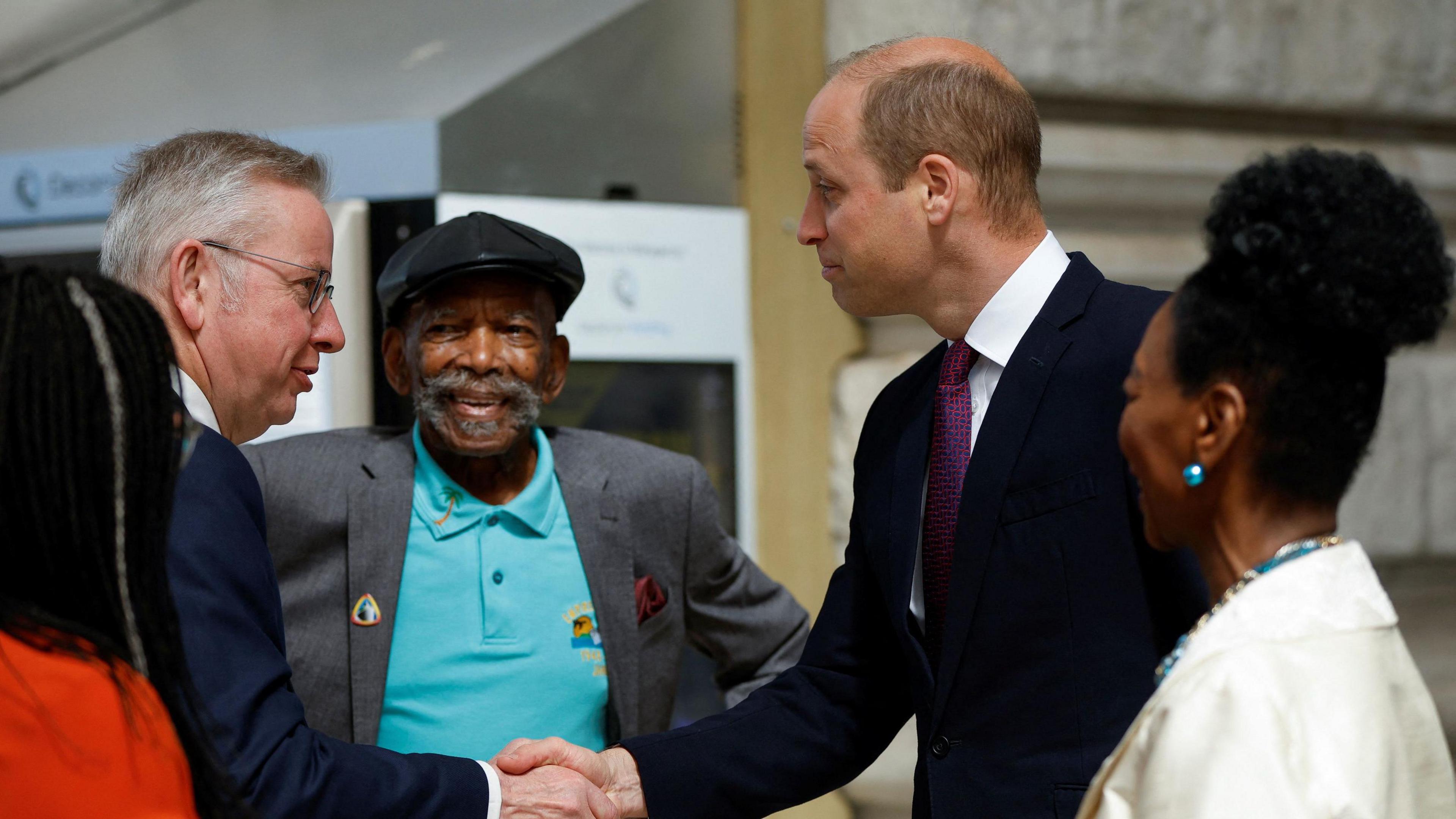 Michael Gove shaking hands with Prince William with Ford Gardner Looking on 