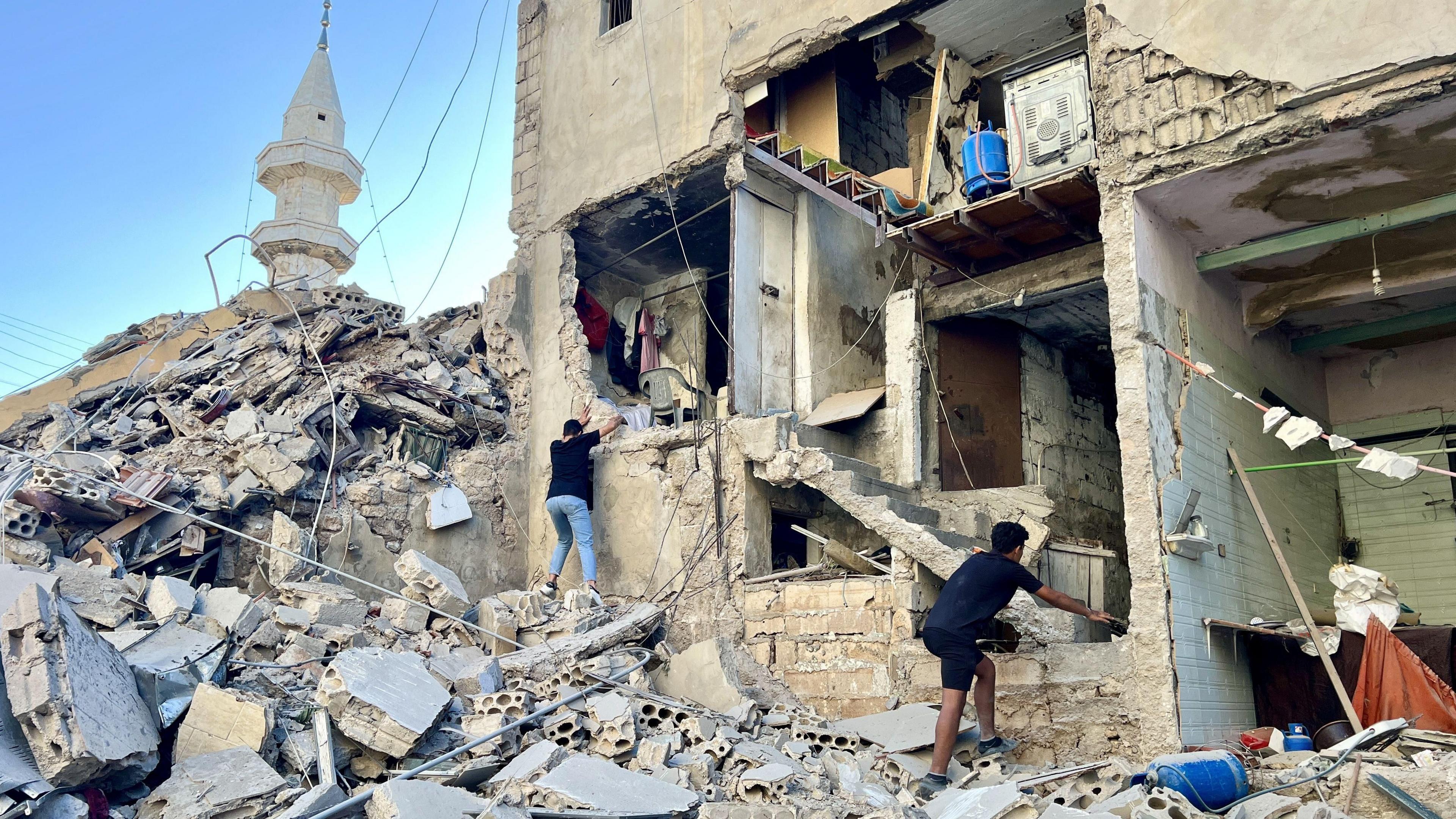 People inspect a damaged building after an Israeli strike on the city of Tyre, Lebanon (23 October 2024)