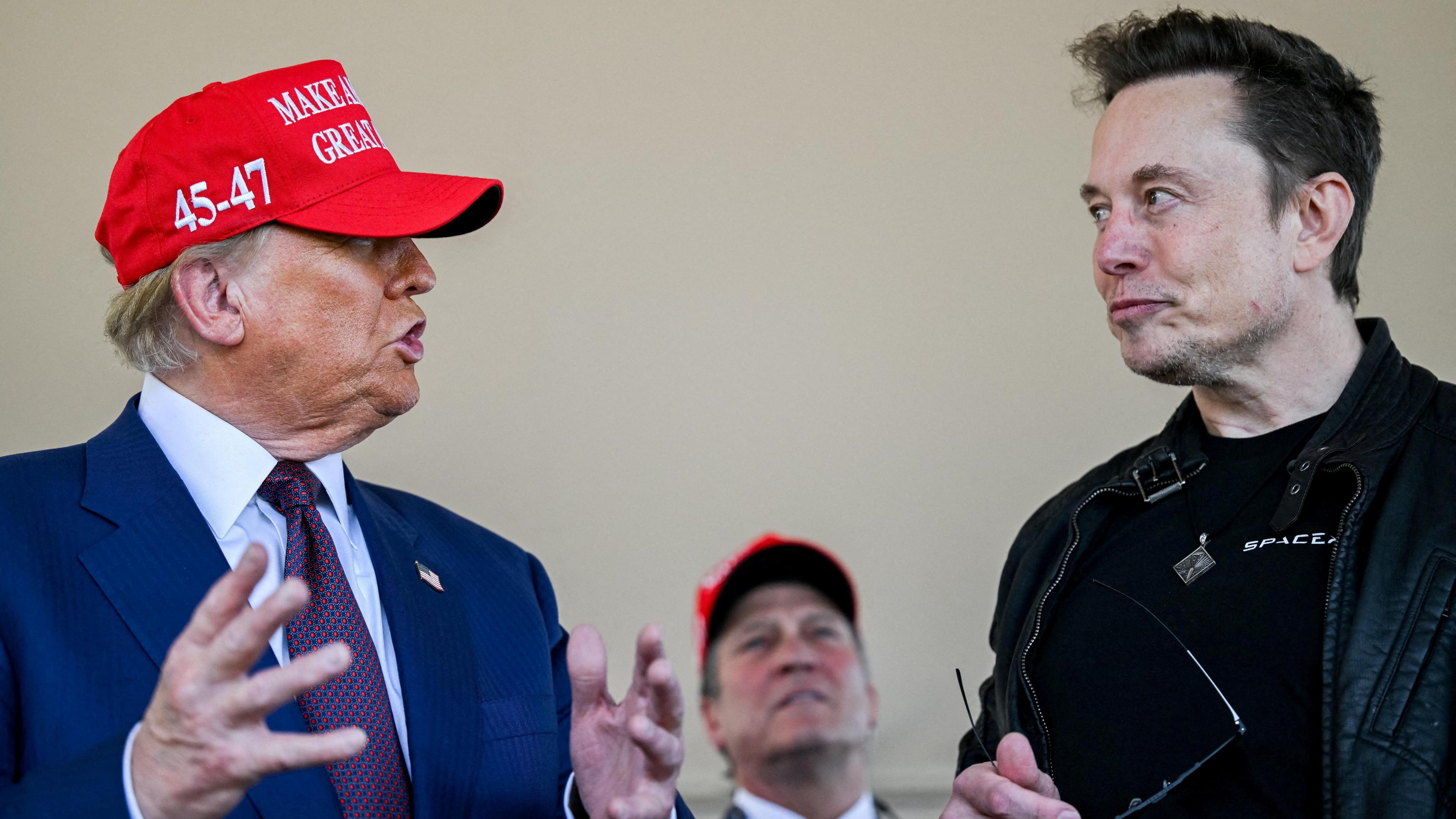 Elon Musk listens in conversation with U.S. President-elect Donald Trump at a viewing of the launch of the sixth test flight of the SpaceX