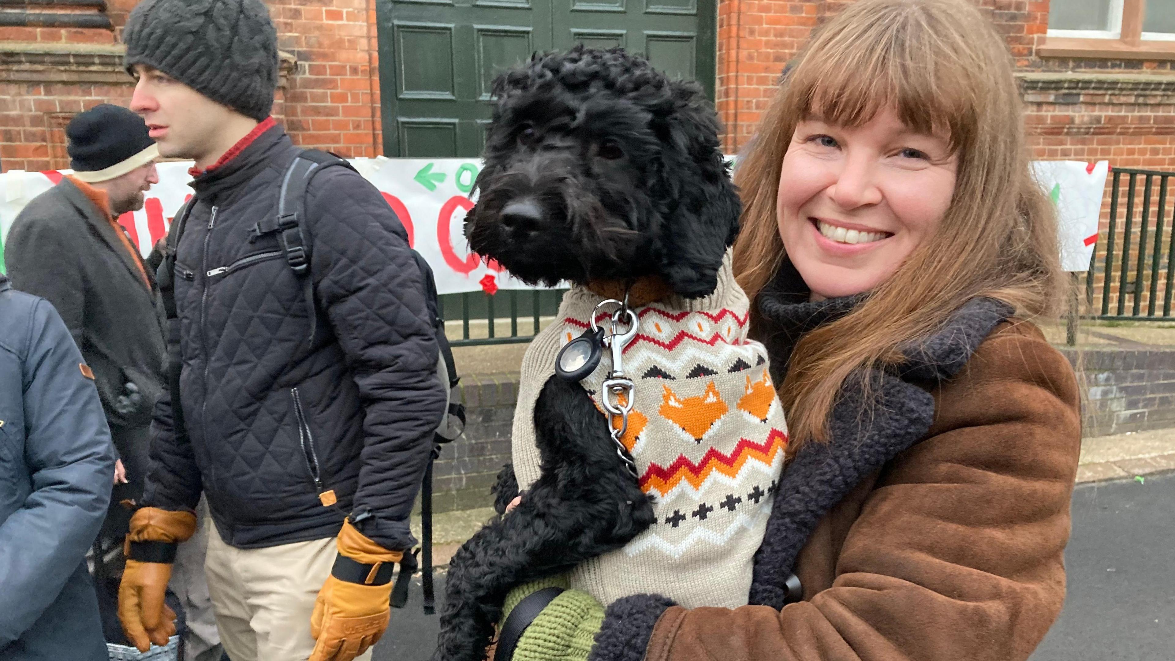 A woman and a dog in a cardigan