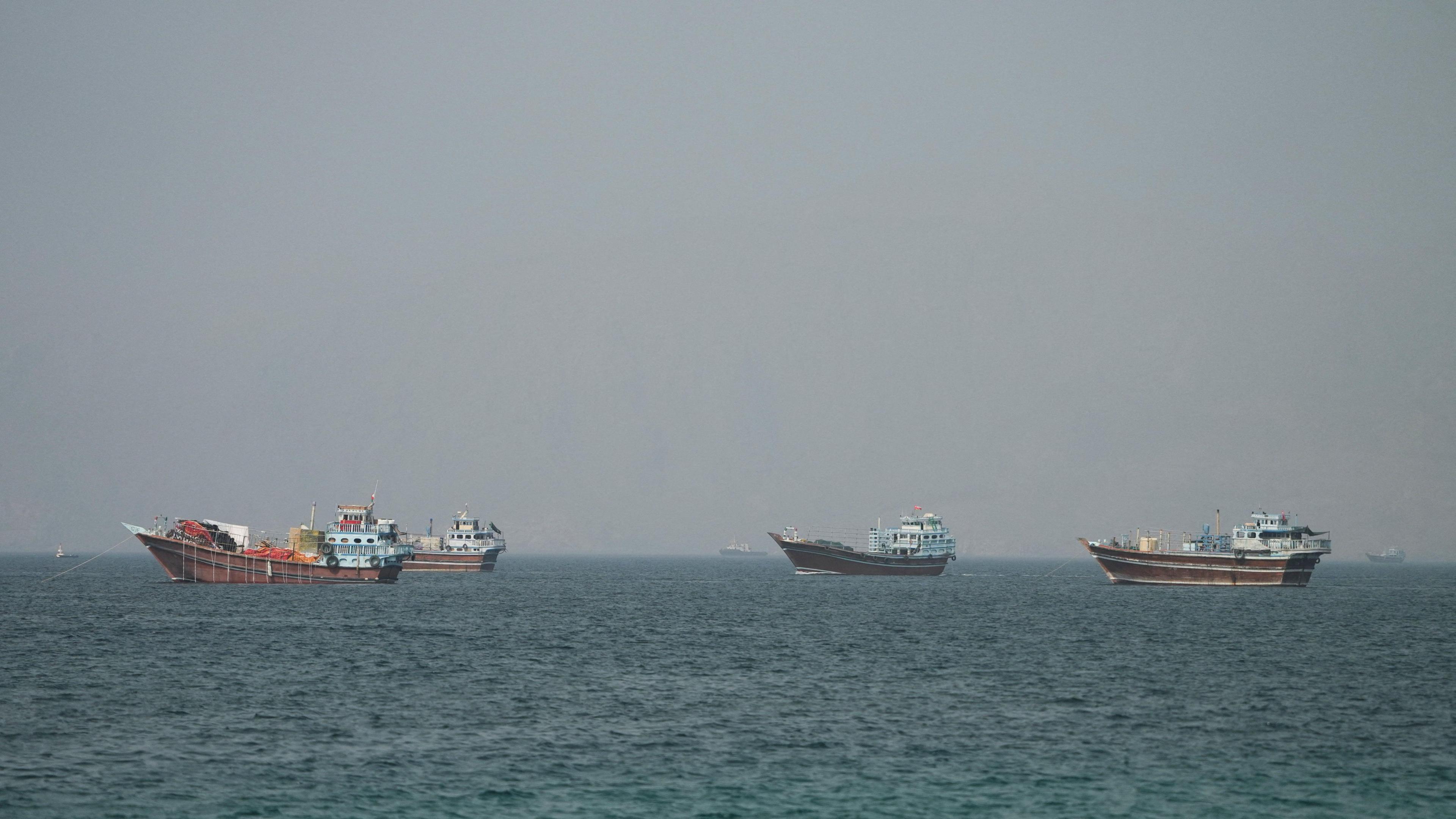Four large boats drifting on the Strait of Hormuz as seen from Oman.