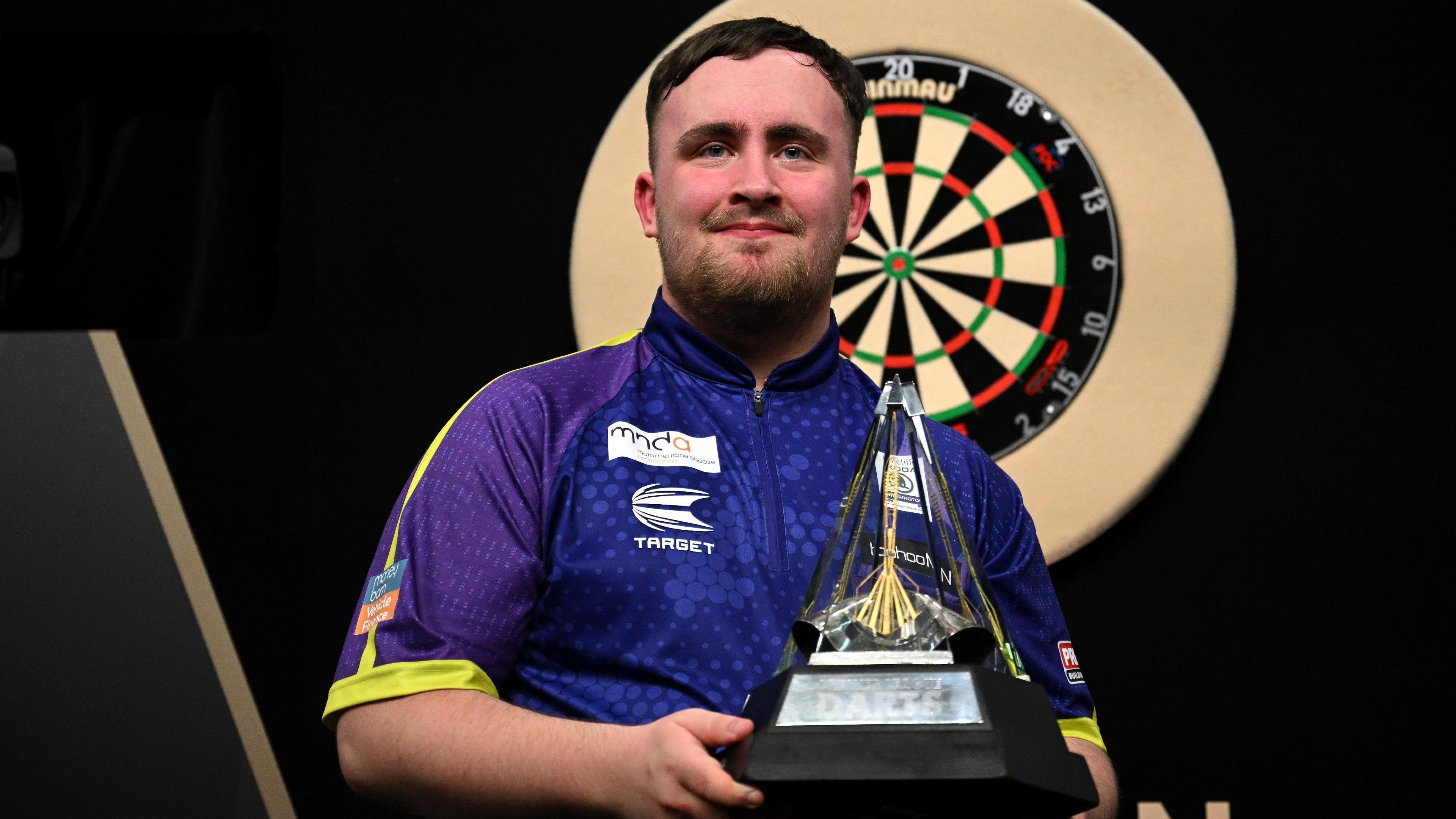 Luke Littler holds a trophy after winning the 2024 Premier League of Darts