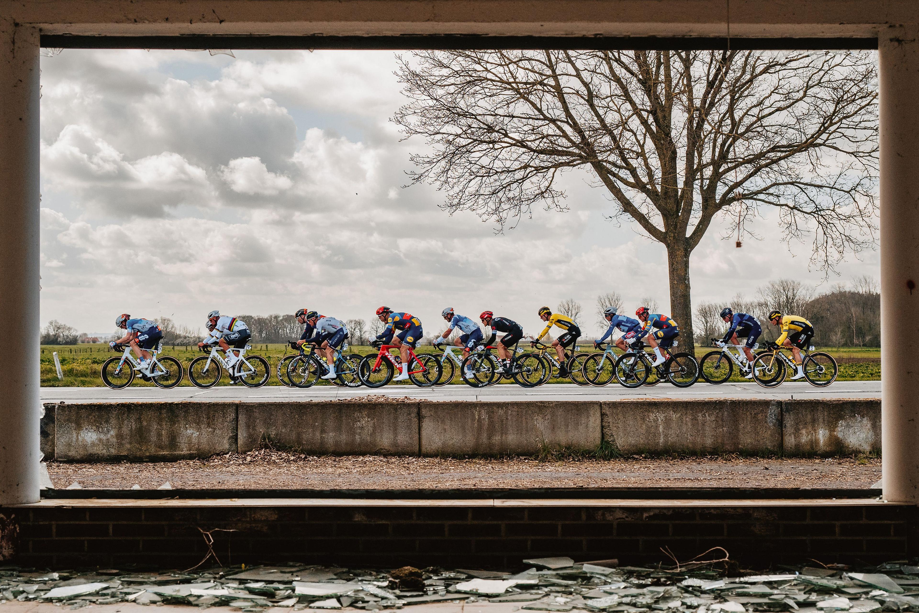 Riders at Gent-Wevelgem, one of the Classics in Belgium, racing past an abandoned house