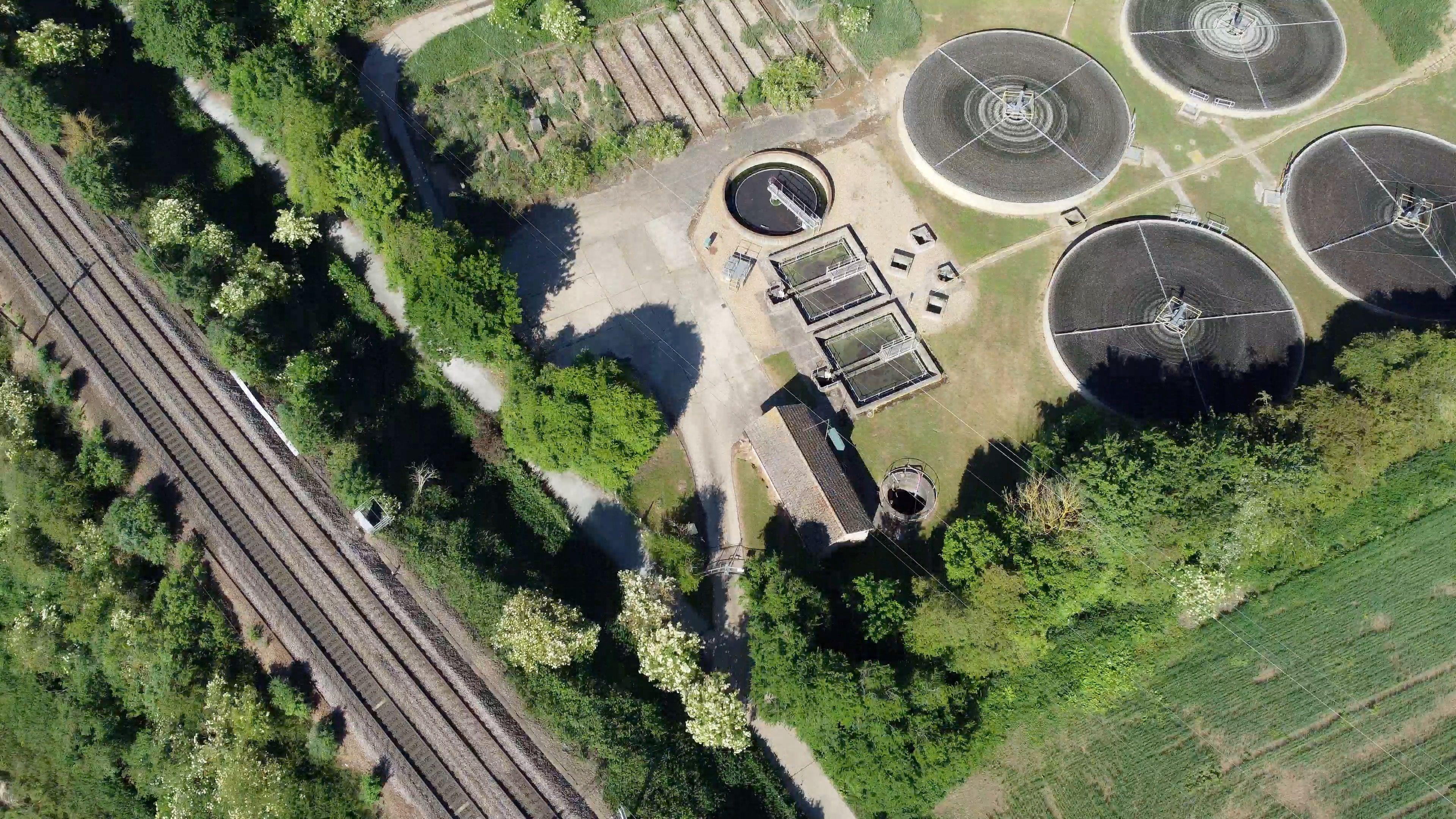 An aerial view of the track running alongside a railway line and Brantham sewage works. The path runs from the middle of the bottom of the photo to the top left