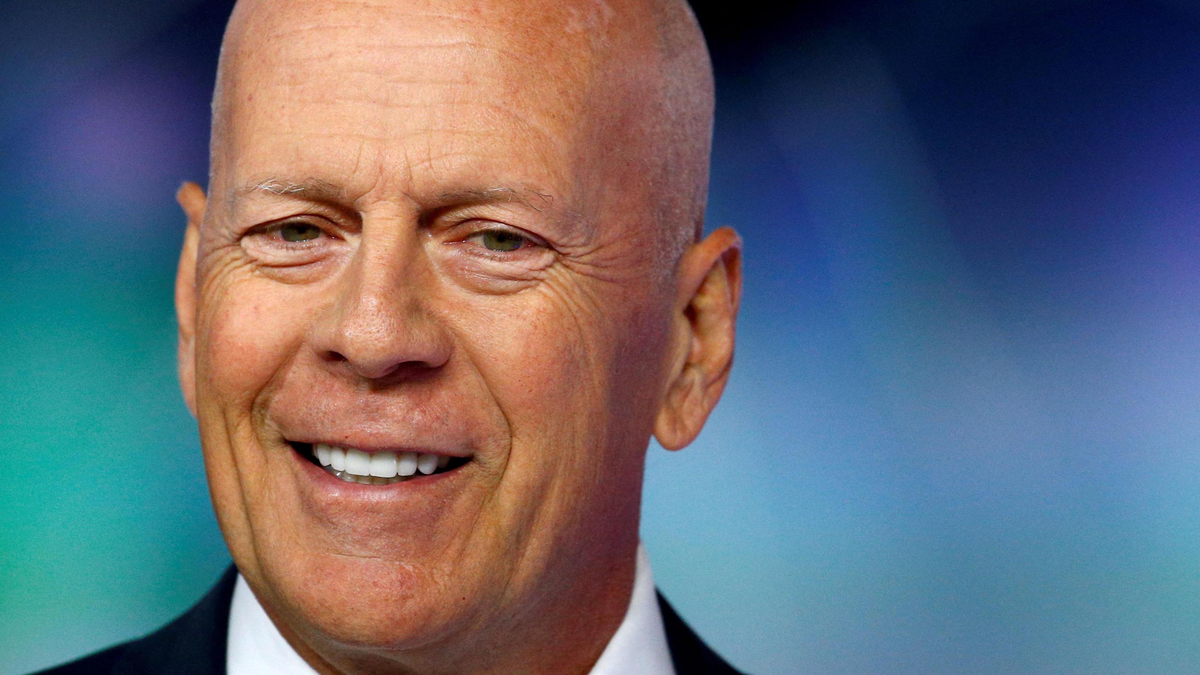 A close-up of actor Bruce Willis attending the European premiere of "Glass" in London, Britain January 9, 2019. He has a bald head and is smiling broadly. Just glimpsed is a black jacket and white shirt. 