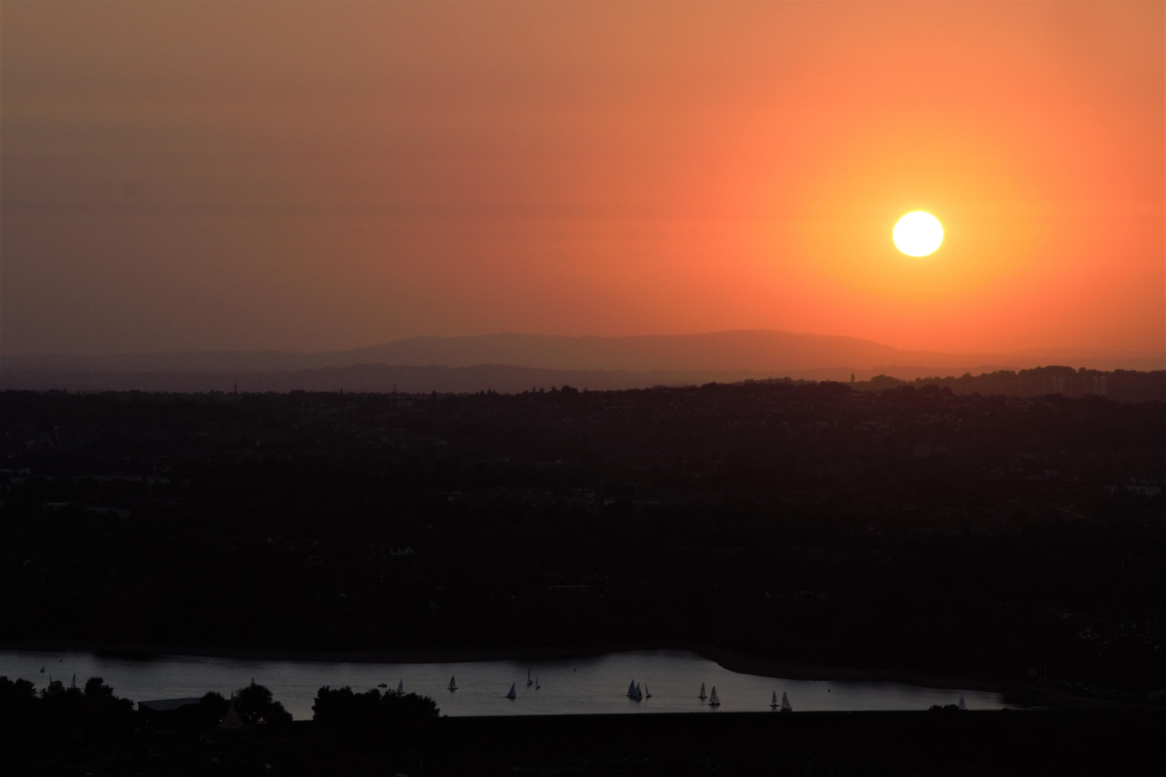 A orange sunset sky overlooking water 