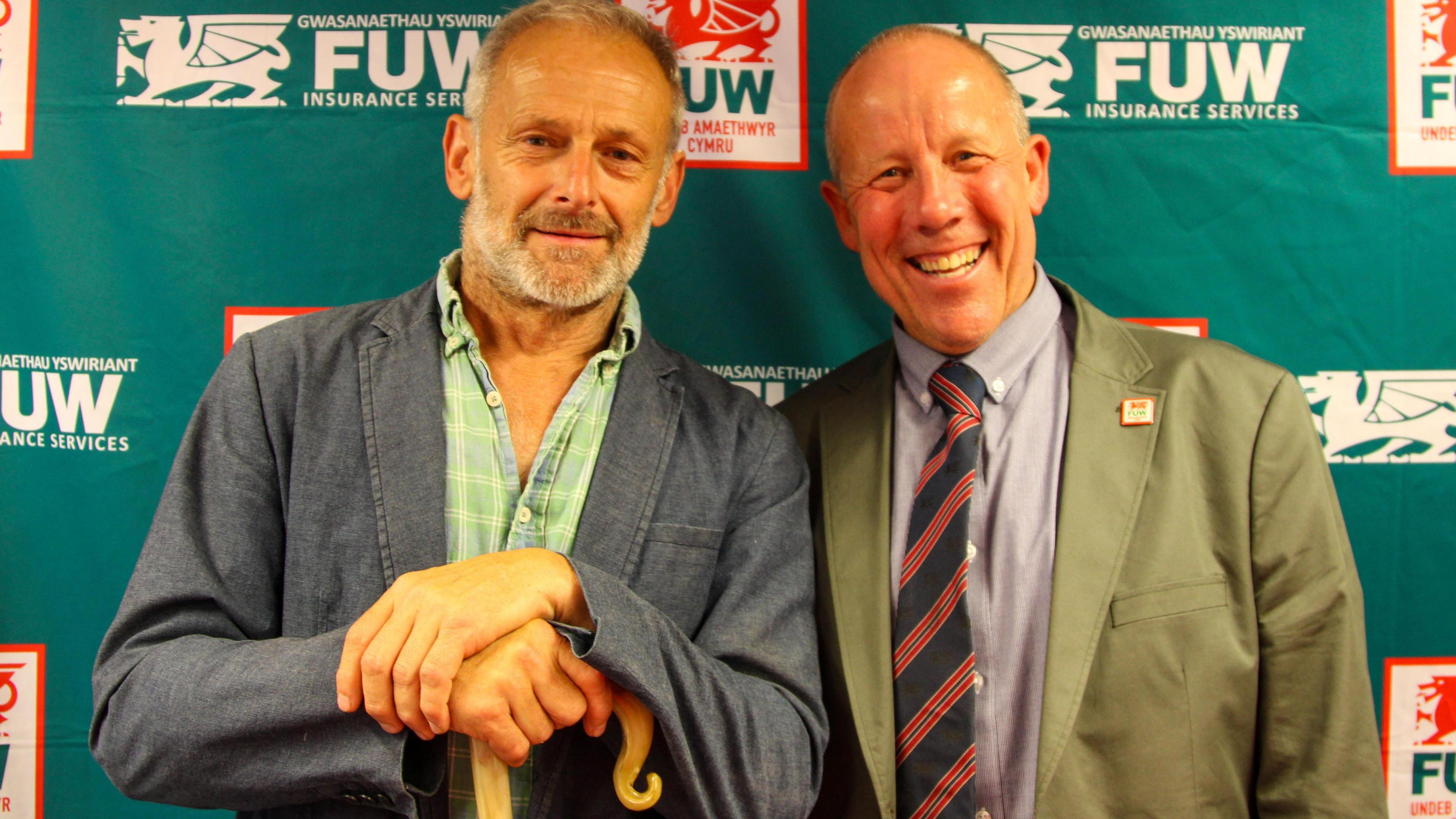 Alun Edwards (chwith) yn derbyn ffon fugail oddi wrth Lywydd Undeb Amaethwyr Cymru Ian Rickman yn y Sioe Frenhinol
