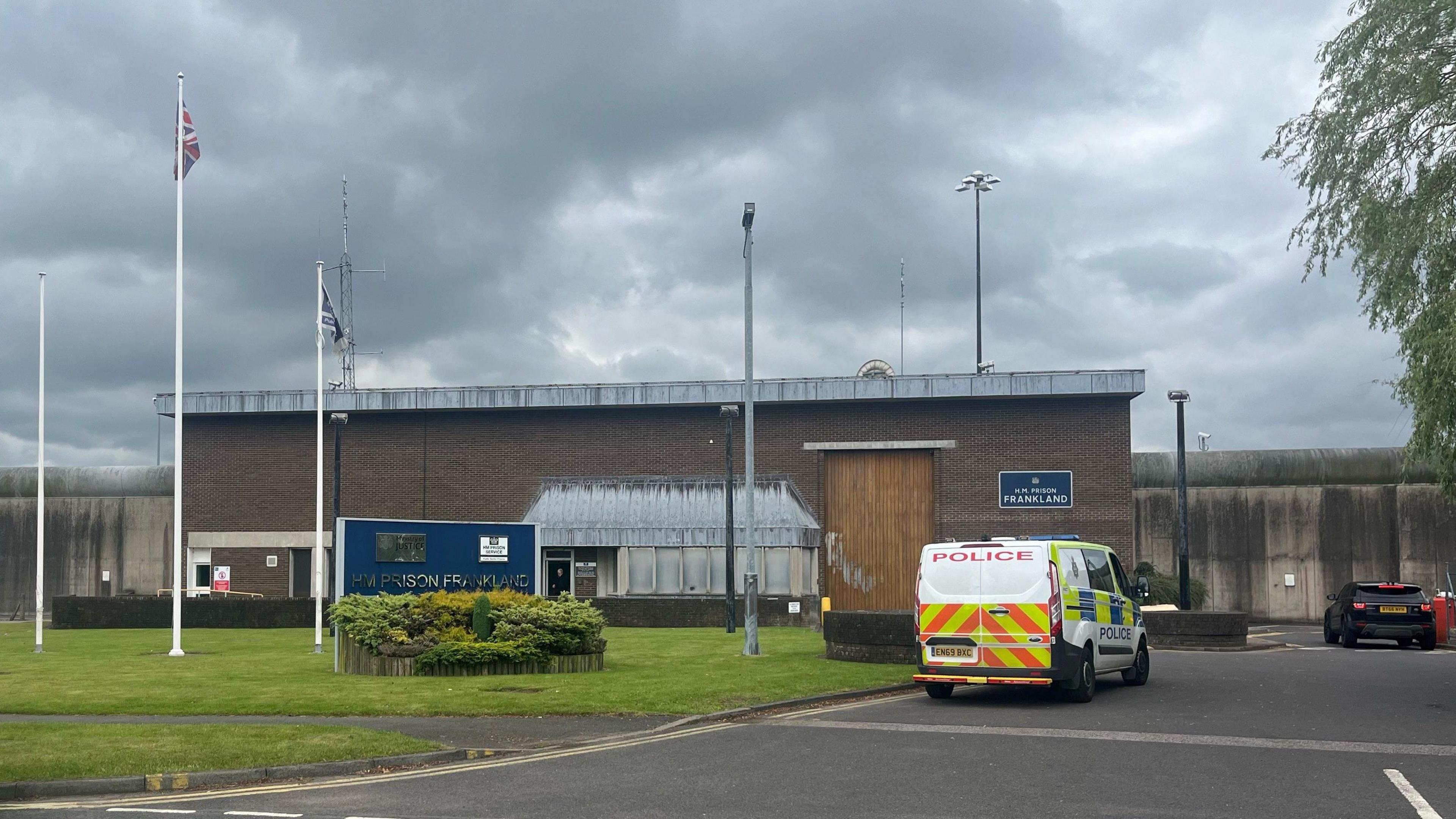 Entrance to HMP FRankland. A police van is parked outside a large brick wall.