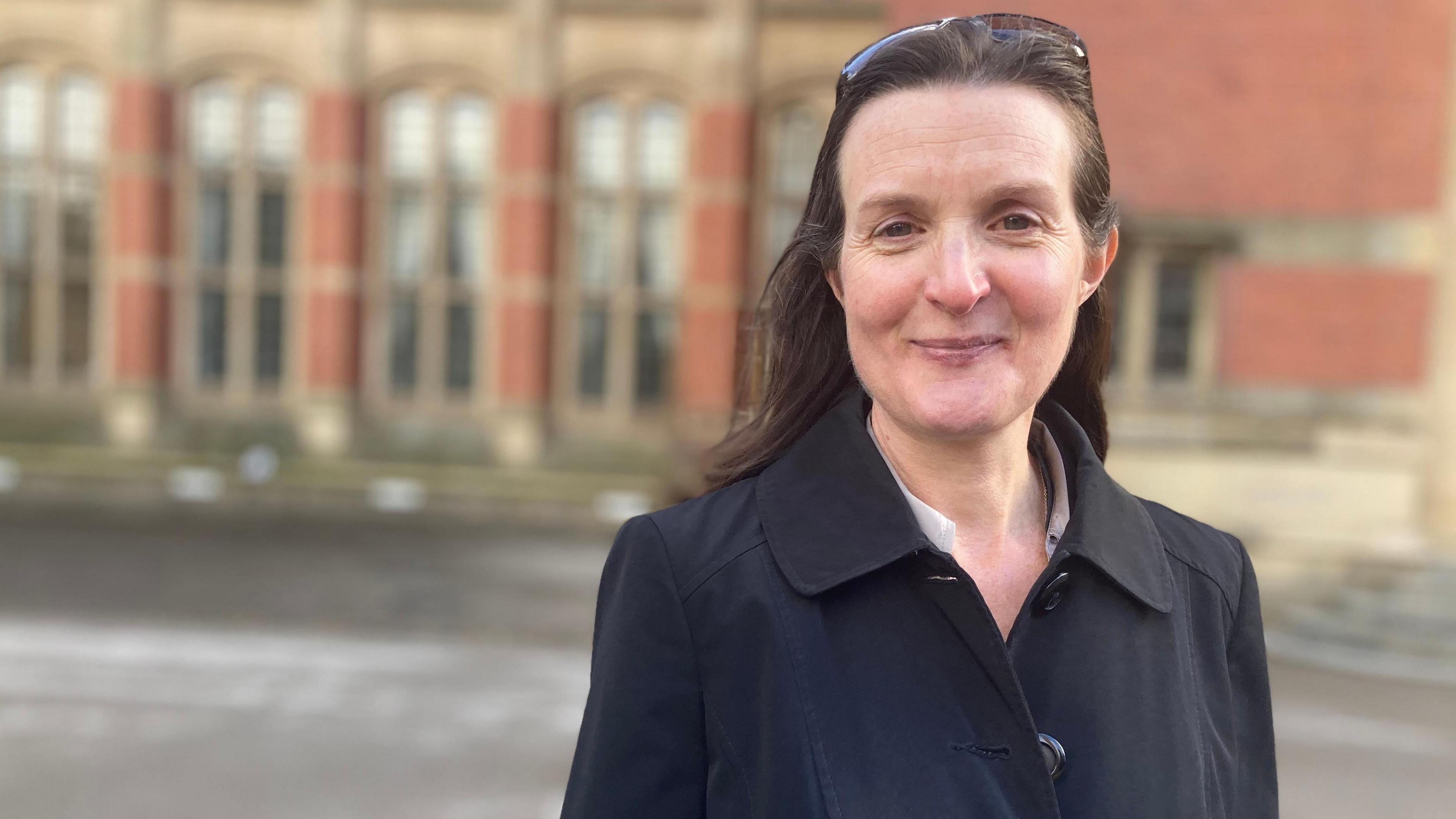 The University of Birmingham's Dominque Moran wearing a black coat with a university building behind her