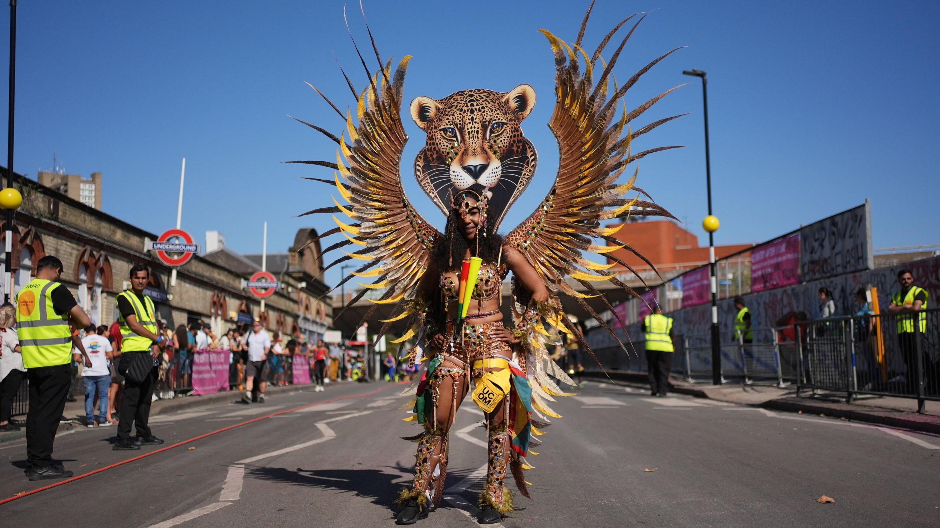 A woman in a carnival costume with a leopard's head above her own. 