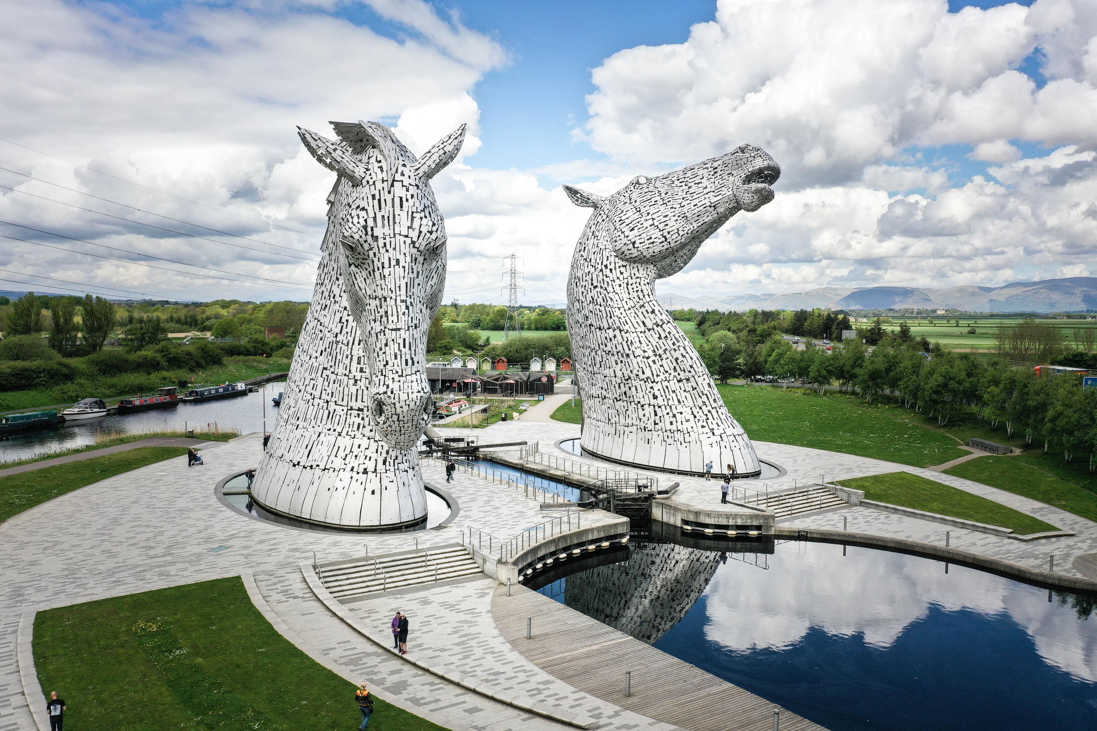 Aerial image of the Kelpies in Falkirk - two large steel sculptures of horse heads with water running between the sculptures and a paved and grass area around each for viewing