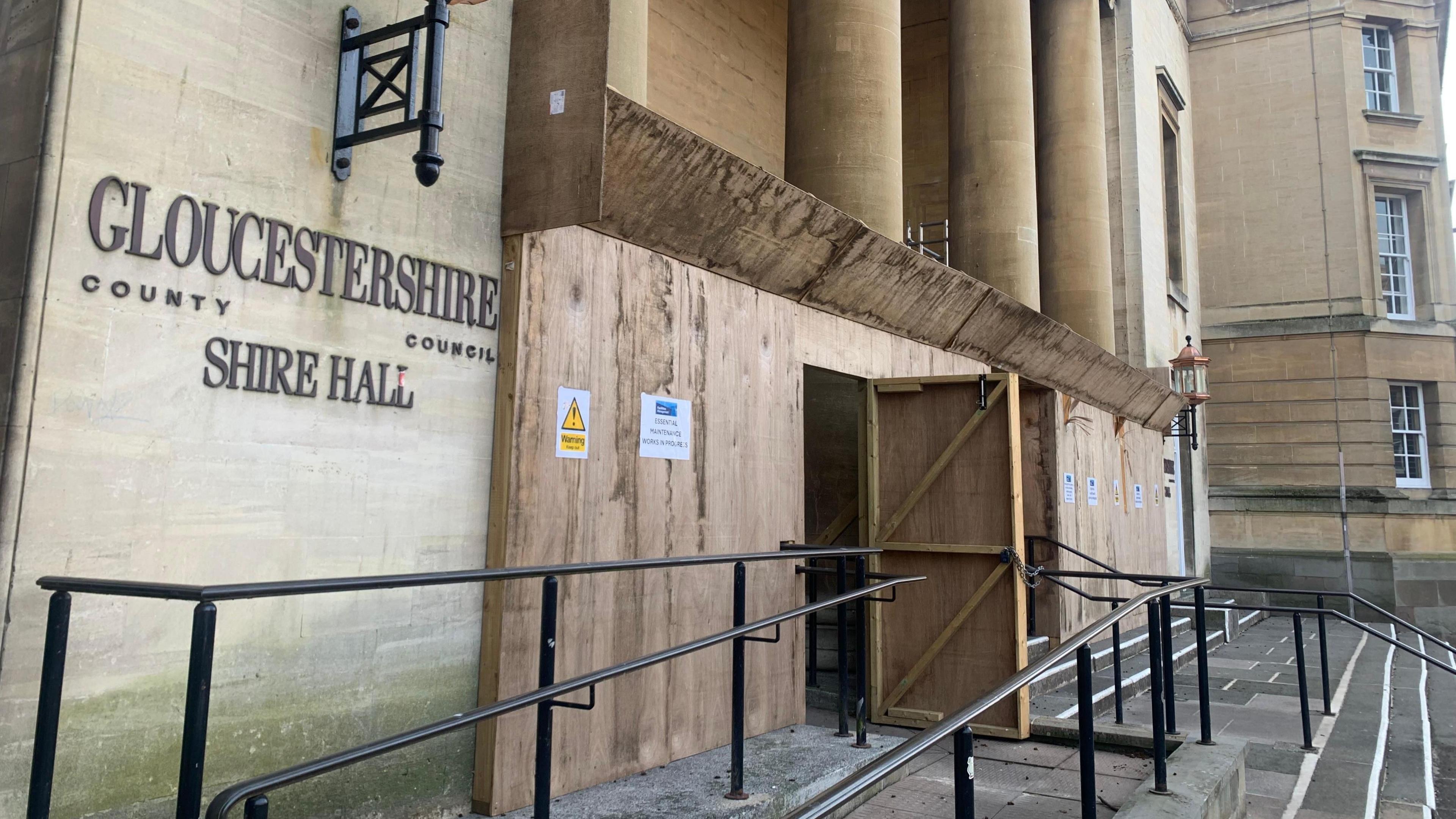 The front of the Shire Hall is boarded up with plywood.