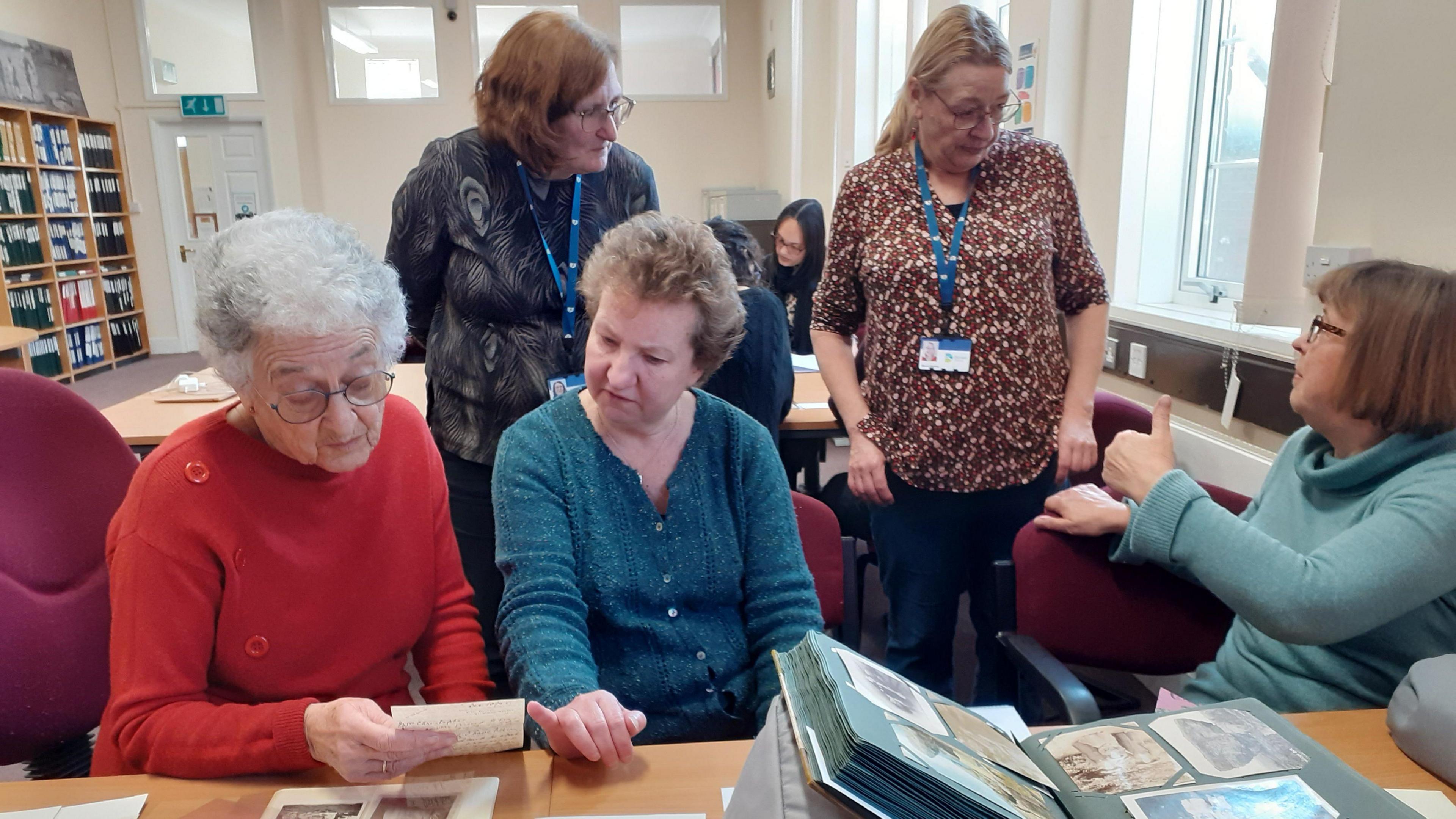 A group of seven women looking through archives at Dorset Museum. 