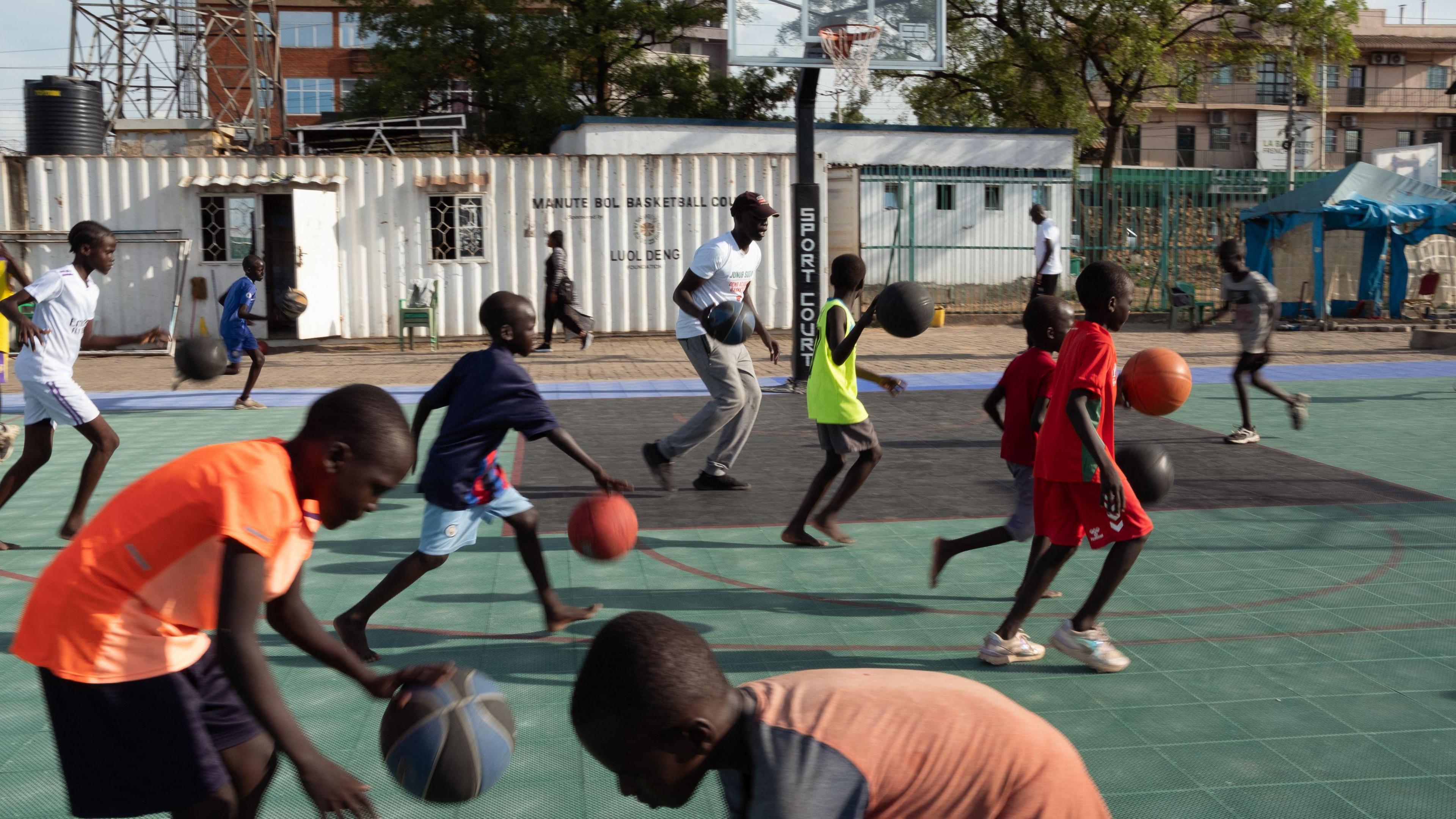 Youngsters dribble basketballs while taking part in a training session at the Luol Deng Basketball Academy in Juba