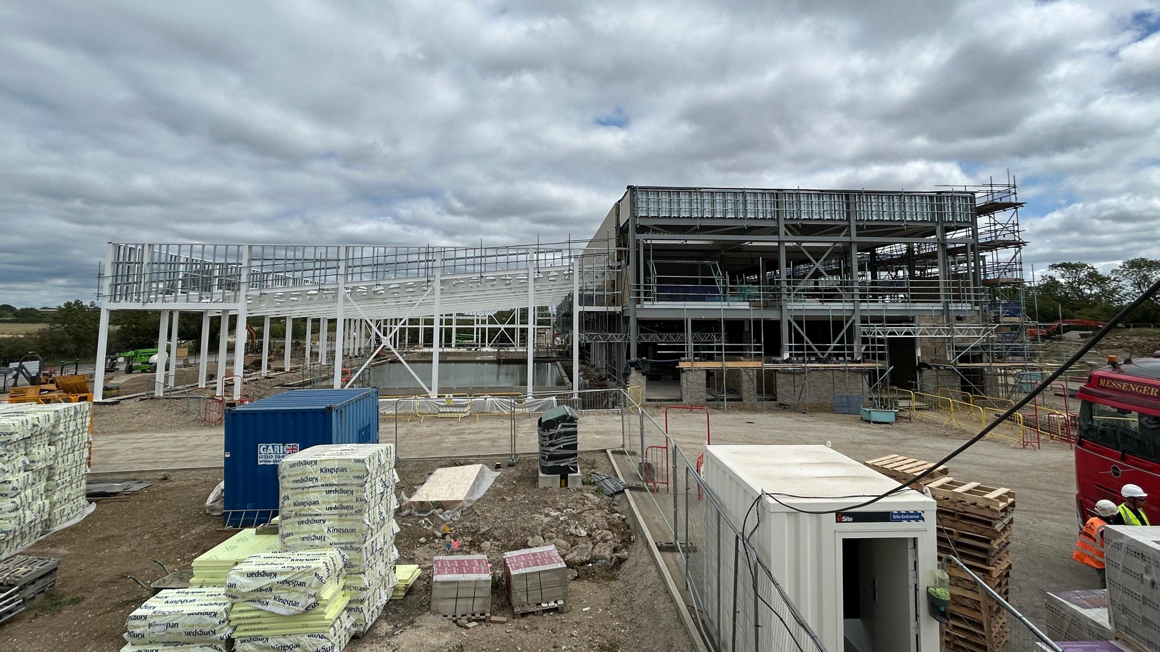 The shell of a leisure facility in Leighton Buzzard is under construction under grey cloud