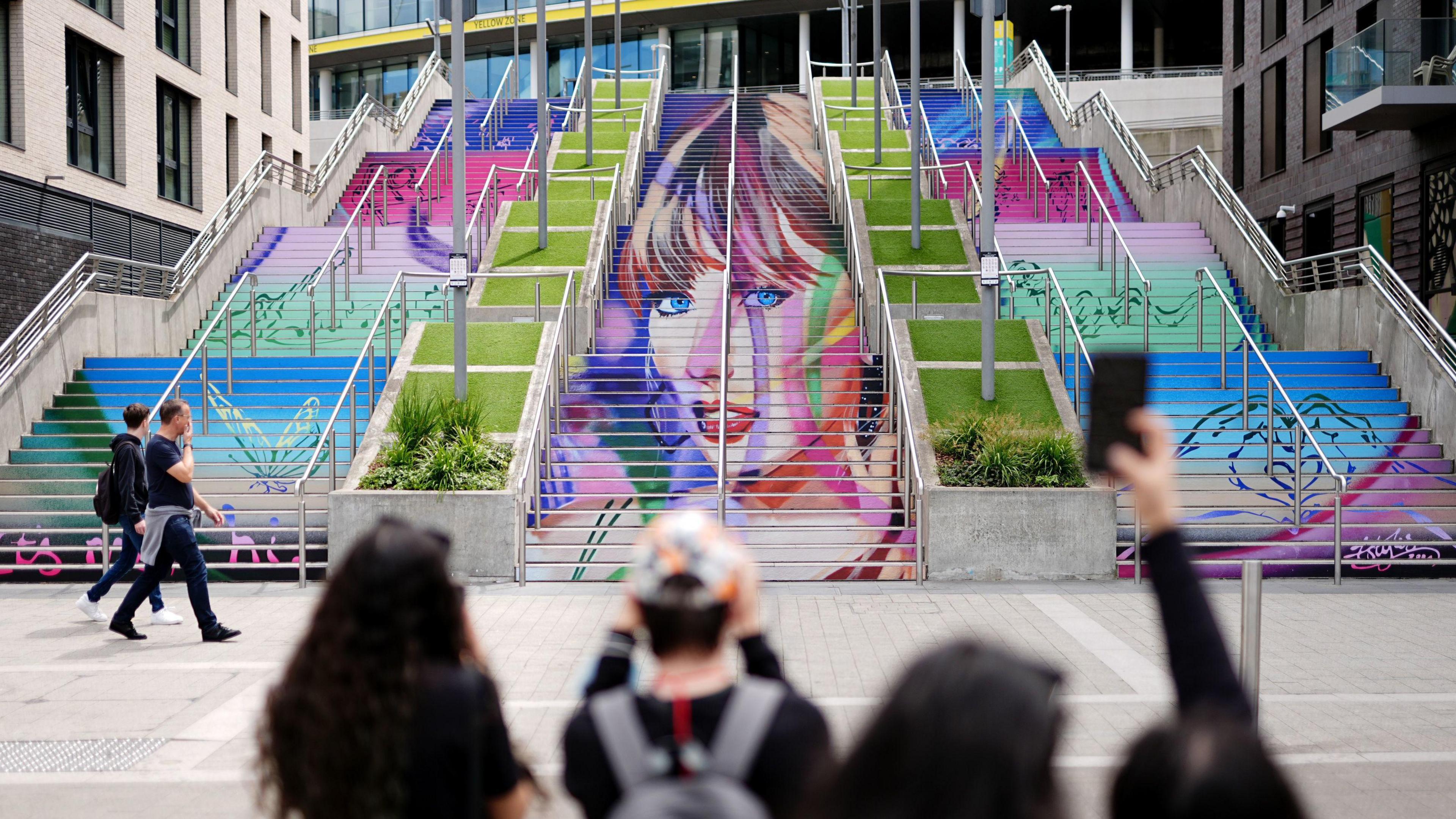 Fans pose next to the special Taylor Swift artwork